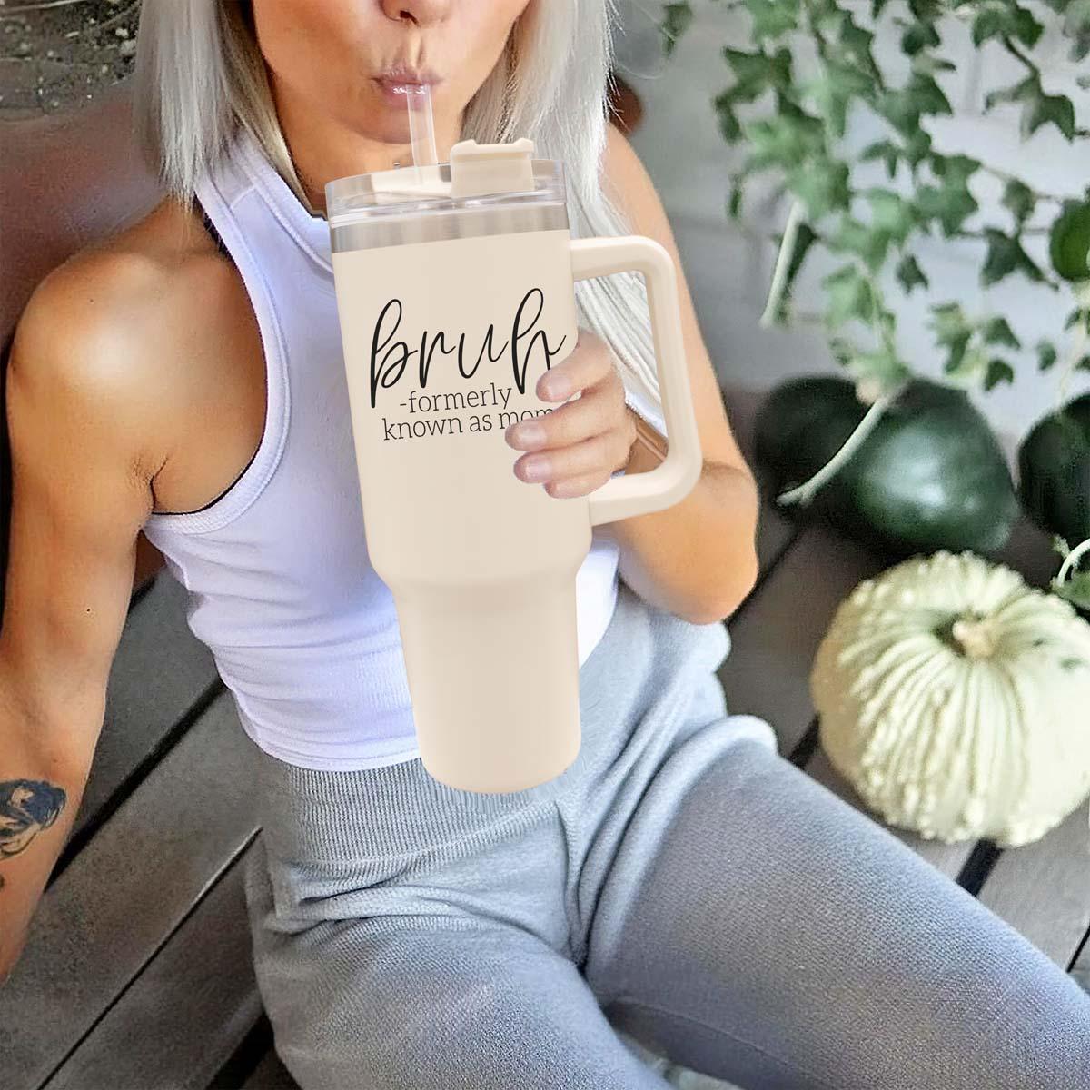 Bruh 40oz tumbler with cream exterior and black graphic design, featuring a handle and a versatile 3-in-1 lid.