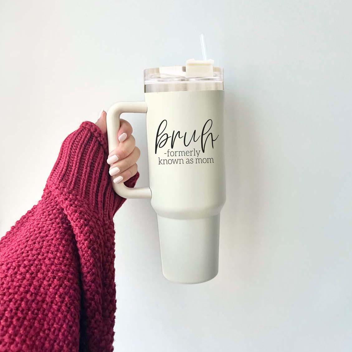 Bruh 40oz tumbler with cream exterior and black graphic design, featuring a handle and a versatile 3-in-1 lid.