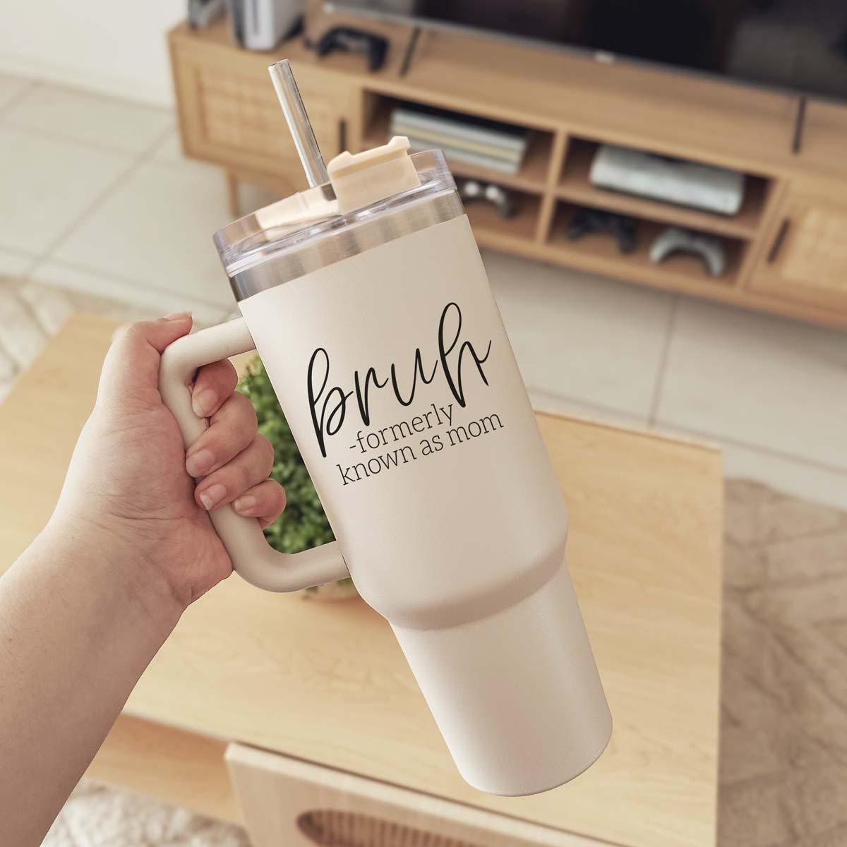 Bruh 40oz tumbler with cream exterior and black graphic design, featuring a handle and a versatile 3-in-1 lid.