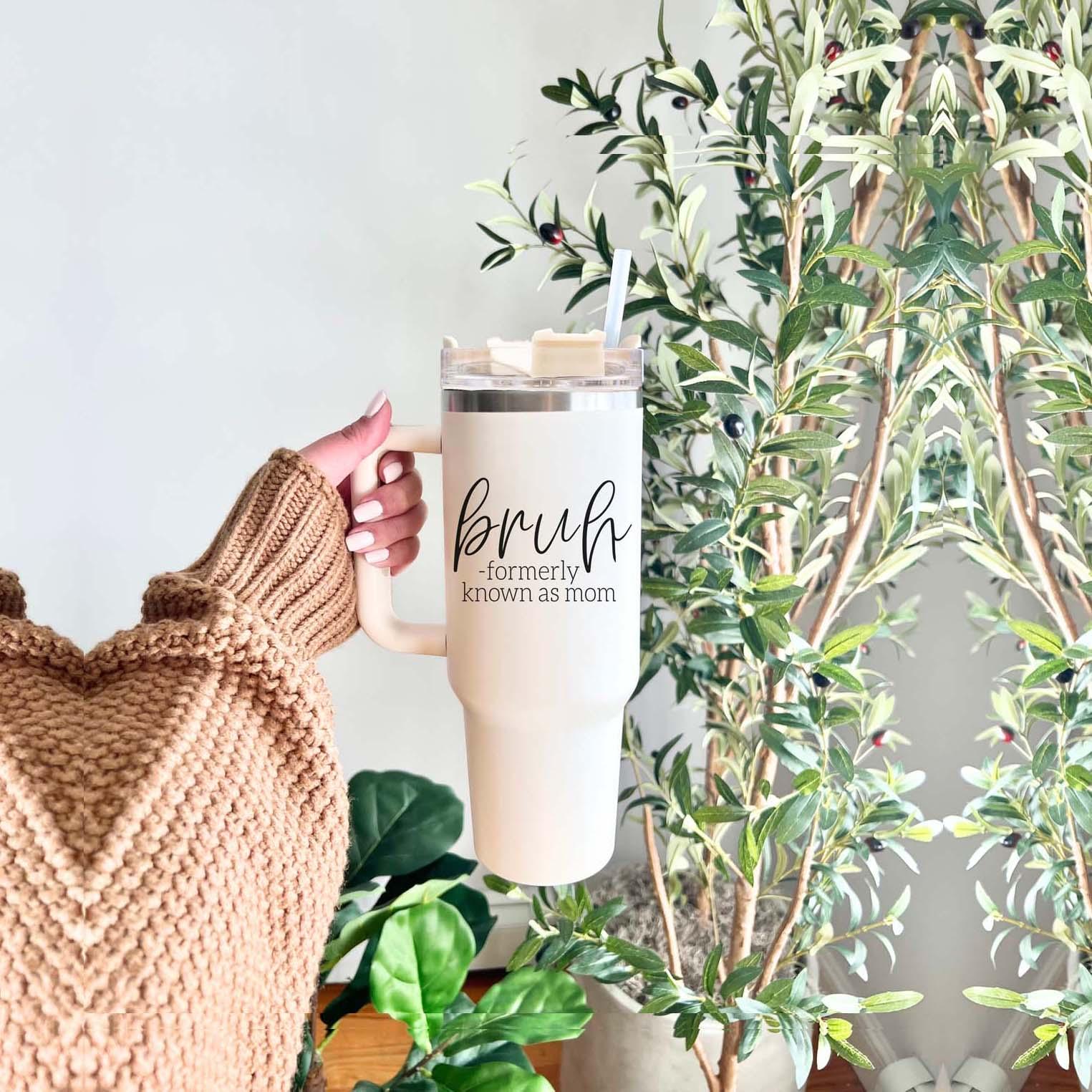 Bruh 40oz tumbler with cream exterior and black graphic design, featuring a handle and a versatile 3-in-1 lid.