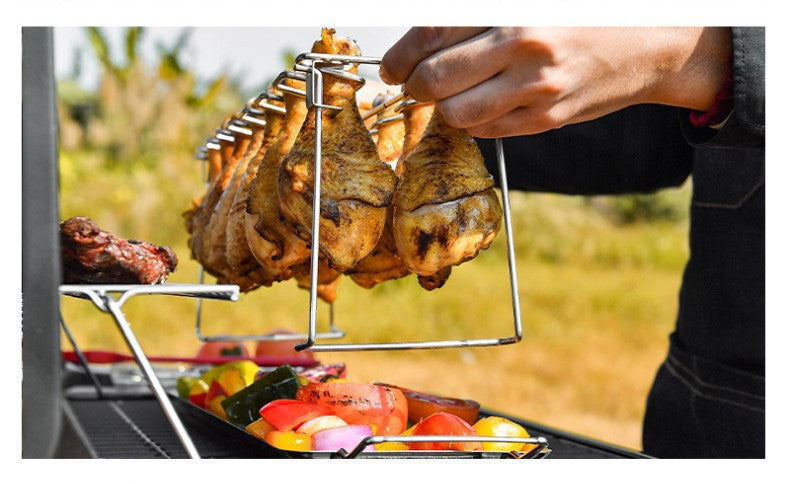 Portable Grilling Basket Mesh Clip with 14 slots, made of stainless steel, featuring a folding stand and drip tray for grilling chicken legs and vegetables.