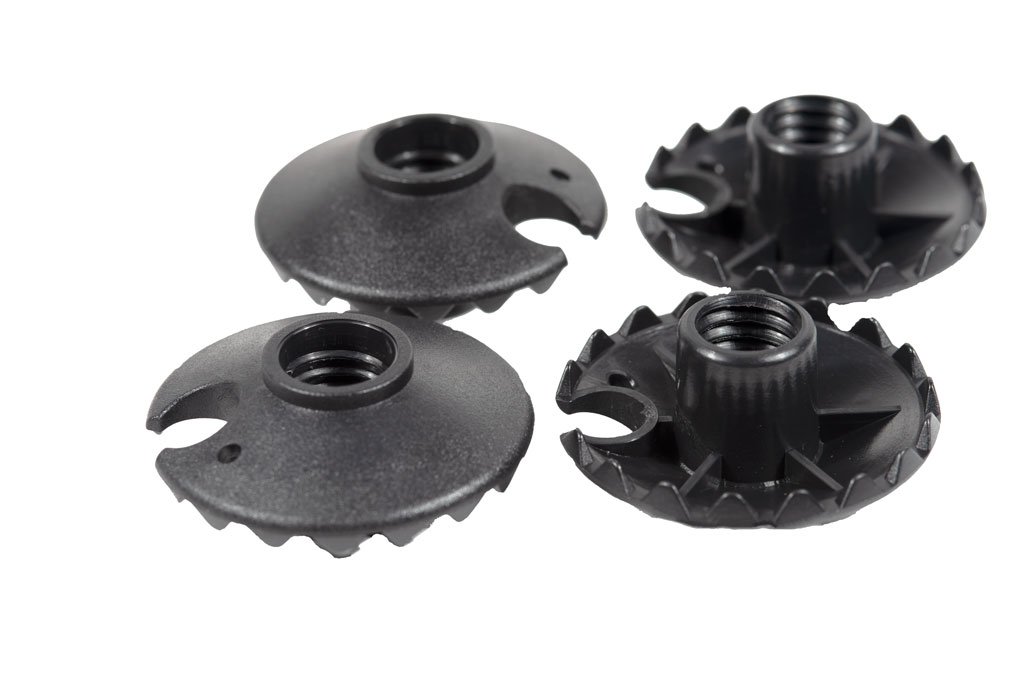 A set of four trekking pole baskets, 50 mm in diameter, designed for mud and snow with serrated edges for enhanced grip.