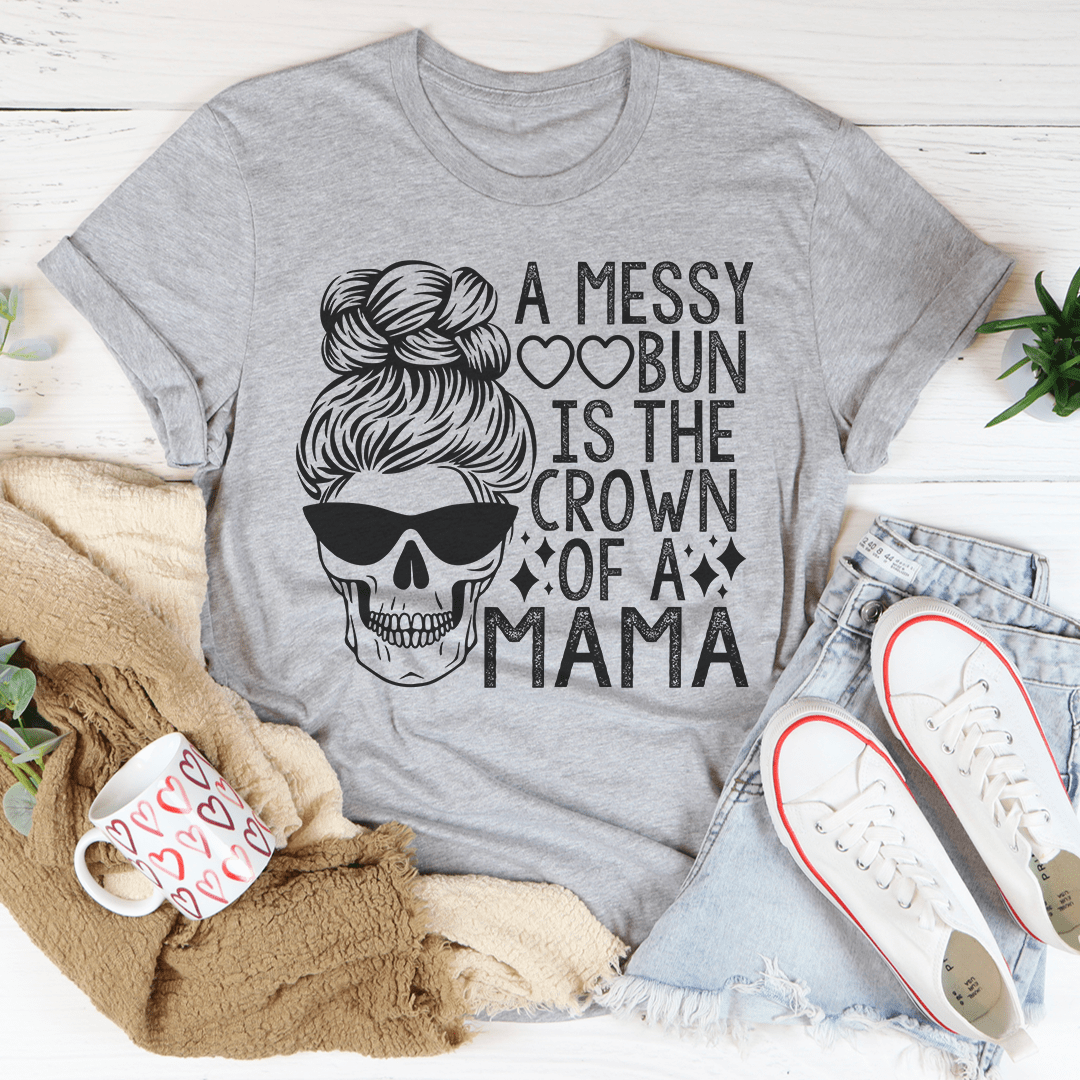 A stylish t-shirt featuring the phrase 'Messy Bun Is The Crown Of A Mama', made from soft cotton with double stitching.
