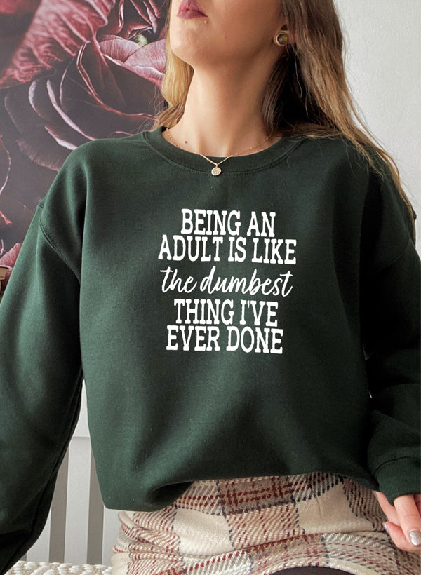 Cozy sweatshirt featuring the phrase 'Adulting Is The Dumbest Thing I've Ever Done' in a stylish design, perfect for casual wear.