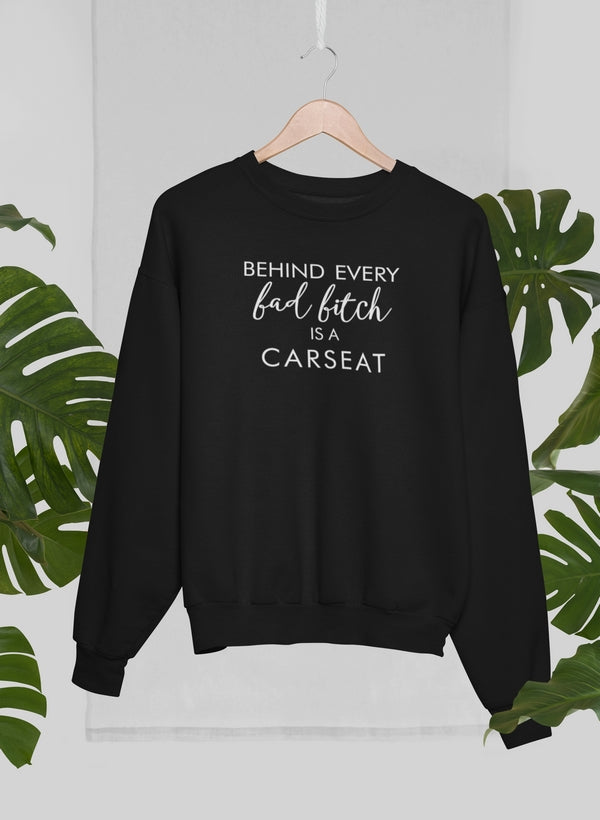 Cozy sweatshirt featuring the phrase 'Behind Every Bad B Is A Car Seat', designed by top artists, made from cotton/poly fleece blend.