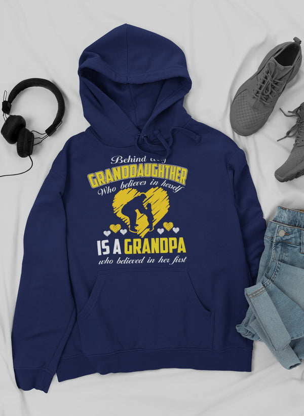 Cozy hoodie featuring the phrase 'Behind Every Granddaughter Who Believes In Herself Is A Grandpa', showcasing a warm fleece design.