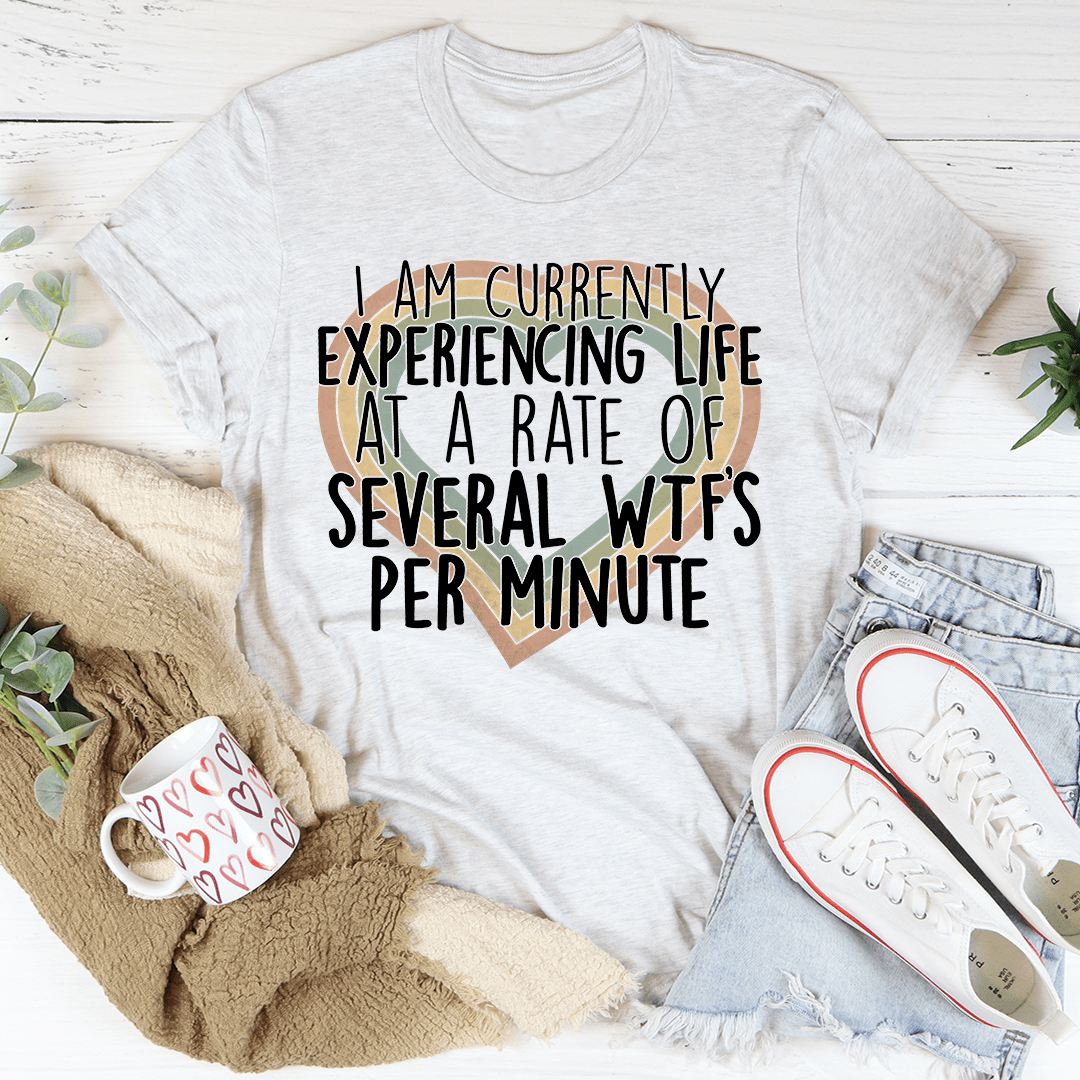 A comfortable and stylish t-shirt featuring the phrase 'Currently Experiencing Life At A Rate Of Several Wtf's Per Minute' printed on it.