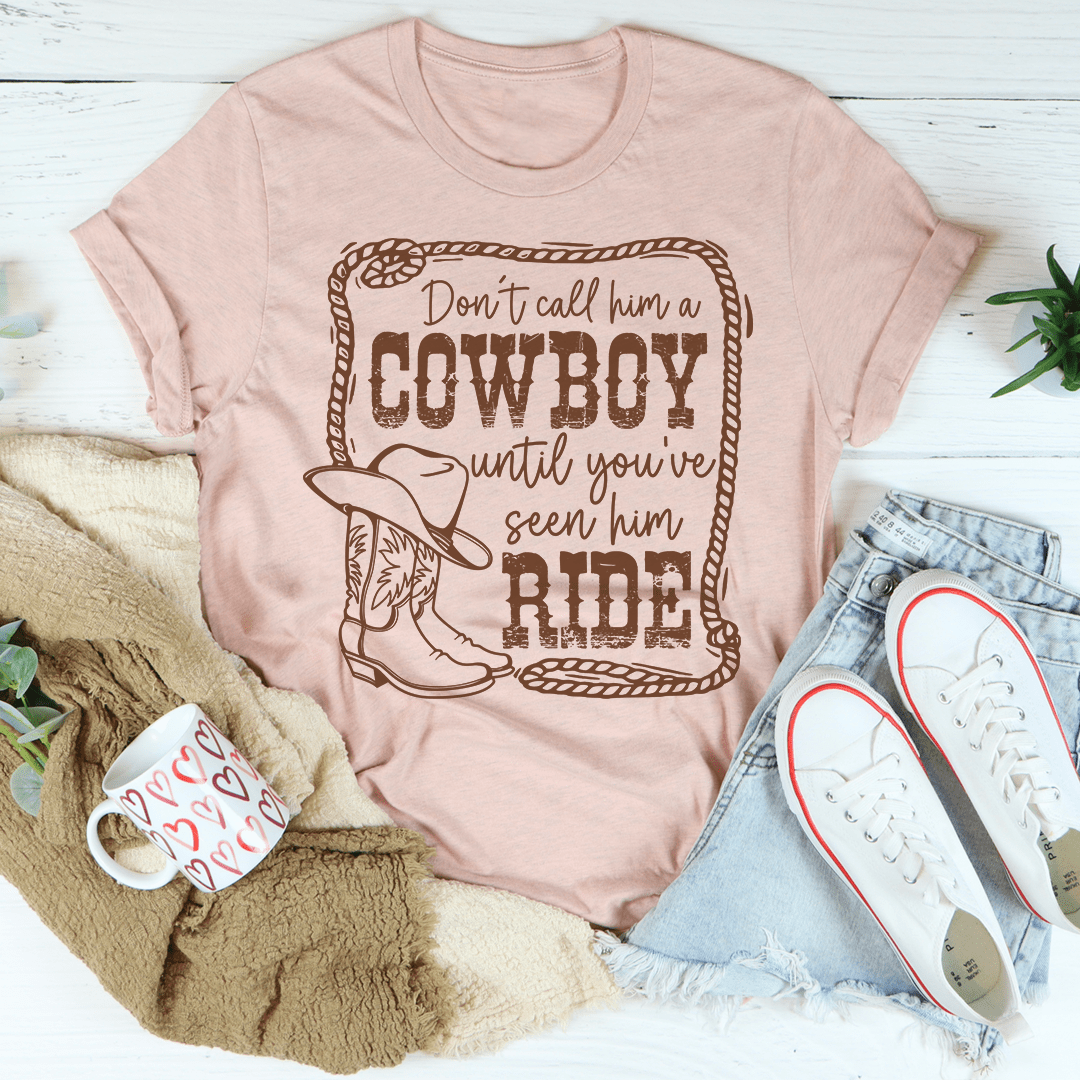 A stylish t-shirt featuring the phrase 'Don't Call Him A Cowboy Until You've Seen Him Ride', made from soft cotton with double stitching.
