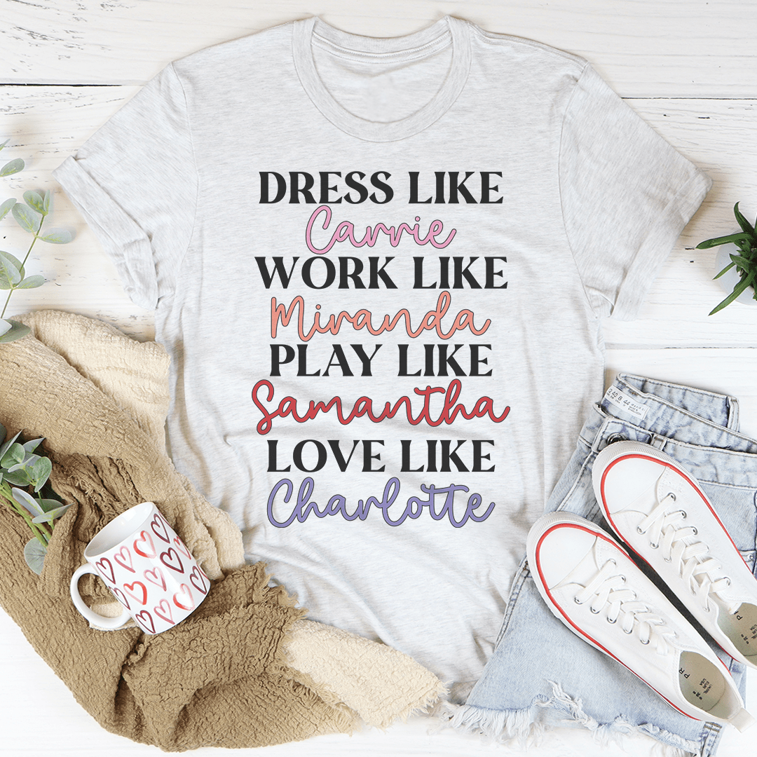 A stylish t-shirt featuring the phrase 'Dress Like Carrie Work Like Miranda Play Like Samantha', made from soft cotton with double stitching.