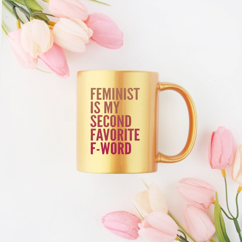 Feminist Is My Second Favorite F Word Mug in gold and silver, showcasing a stylish design on a ceramic material.