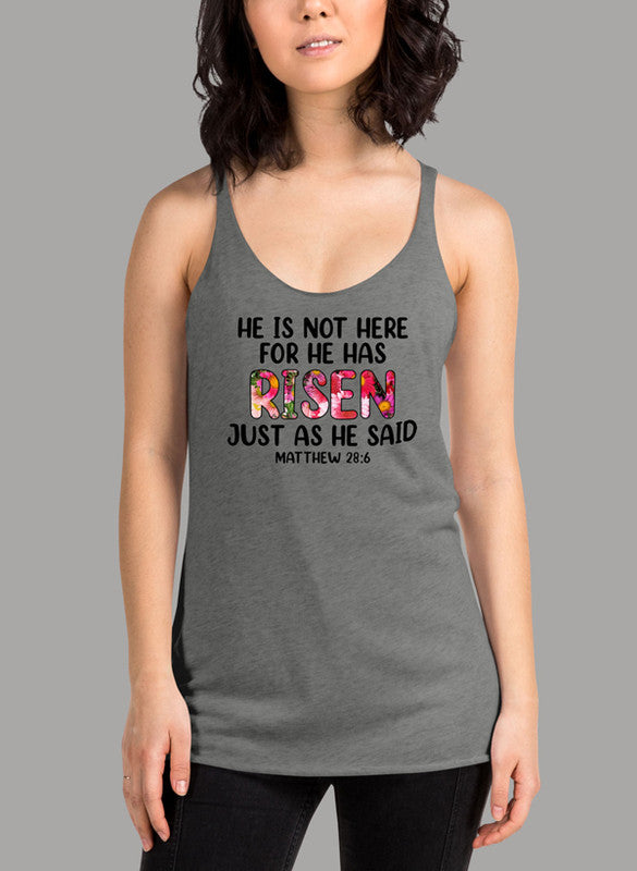 Black women's tank top featuring racer back style and curved hem, with the text 'He Is Not Here For He Has Risen'.