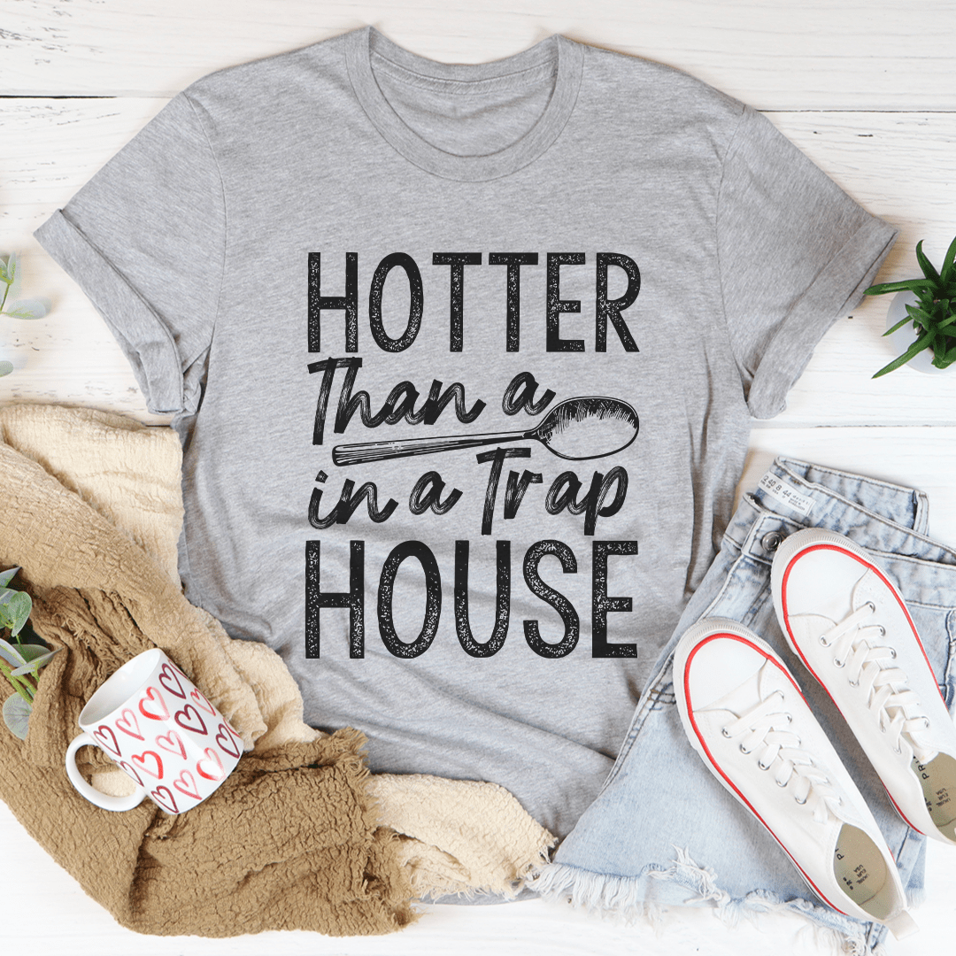 A stylish black t-shirt featuring the phrase 'Hotter Than A Spoon In A Trap House' printed in bold letters, showcasing its comfortable fit and quality fabric.