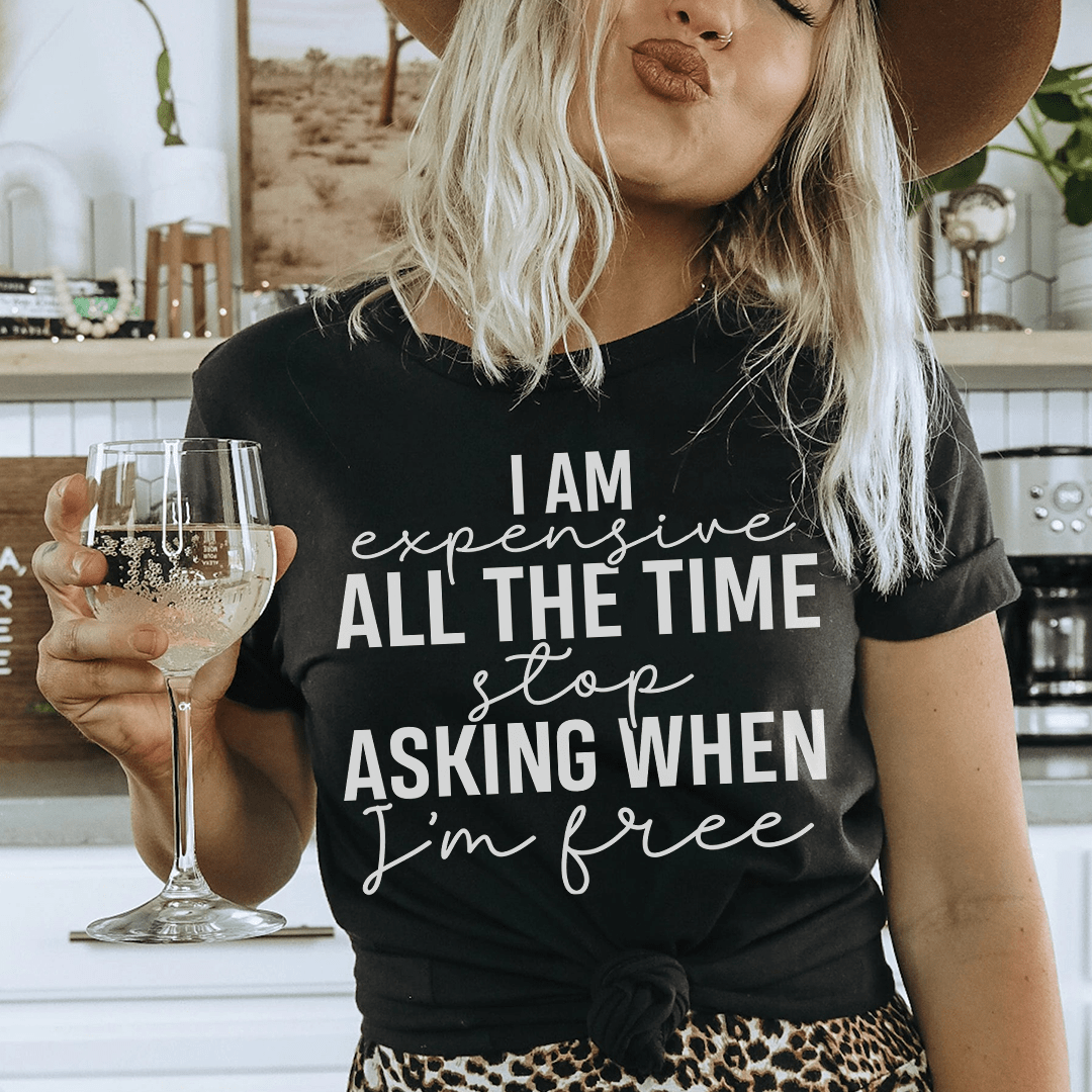A stylish black t-shirt with the phrase 'I Am Expensive All The Time Stop Asking When I'm Free' printed in bold white letters.