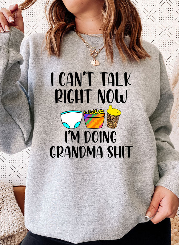Cozy sweatshirt with 'I Can't Talk Right Now I'm Doing Grandma Stuff' printed design, featuring adjustable banded cuffs and fleece lining.