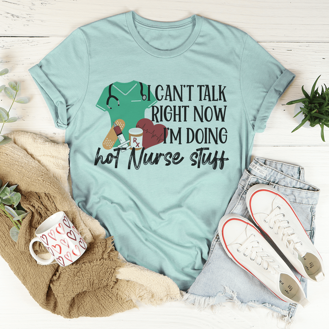 A humorous t-shirt featuring the phrase 'I Can't Talk Right Now I'm Doing Hot Nurse Stuff', made from soft cotton with double stitching.