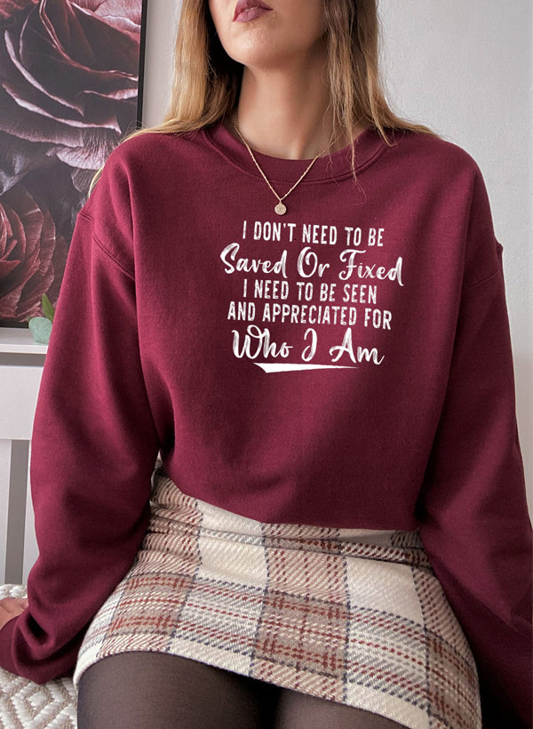 A cozy sweatshirt featuring the phrase 'I Don't Need To Be Saved Or Fixed', made from cotton/poly fleece blend, perfect for casual wear.