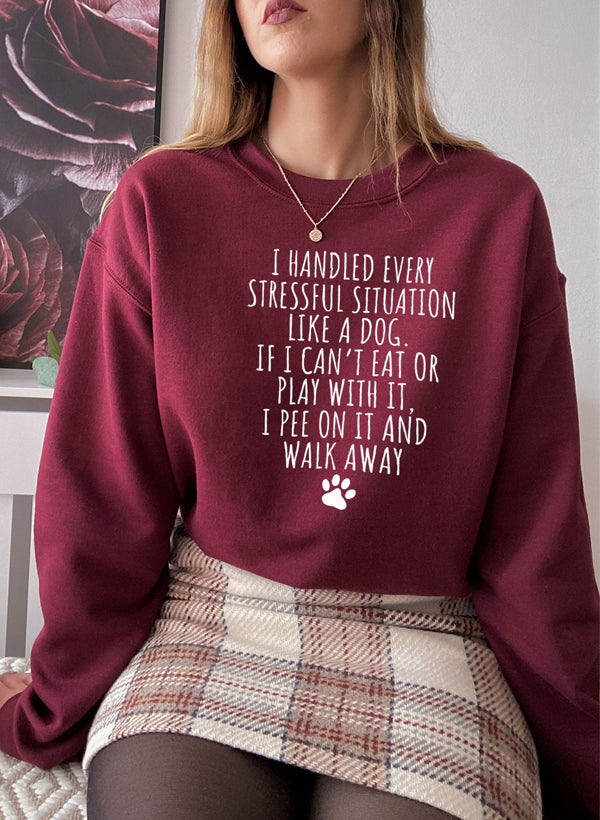 A cozy sweatshirt featuring the humorous slogan 'I Handled Every Stressful Situation Like A Dog', made from a soft cotton/poly fleece blend.
