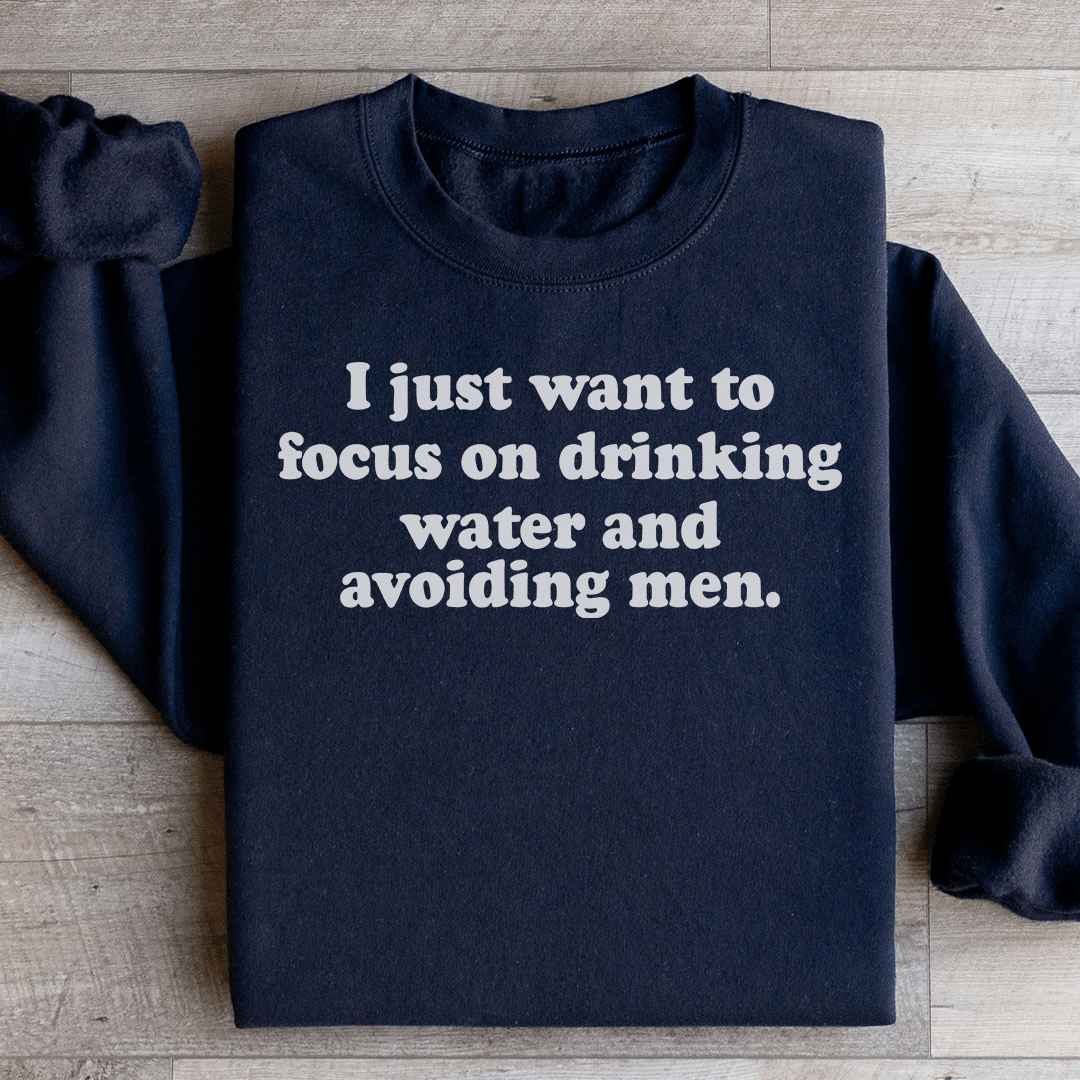Cozy hoodie with unique design featuring the phrase 'I Just Want to Focus On Drinking Water And Avoiding Men', made from cotton/poly fleece blend.