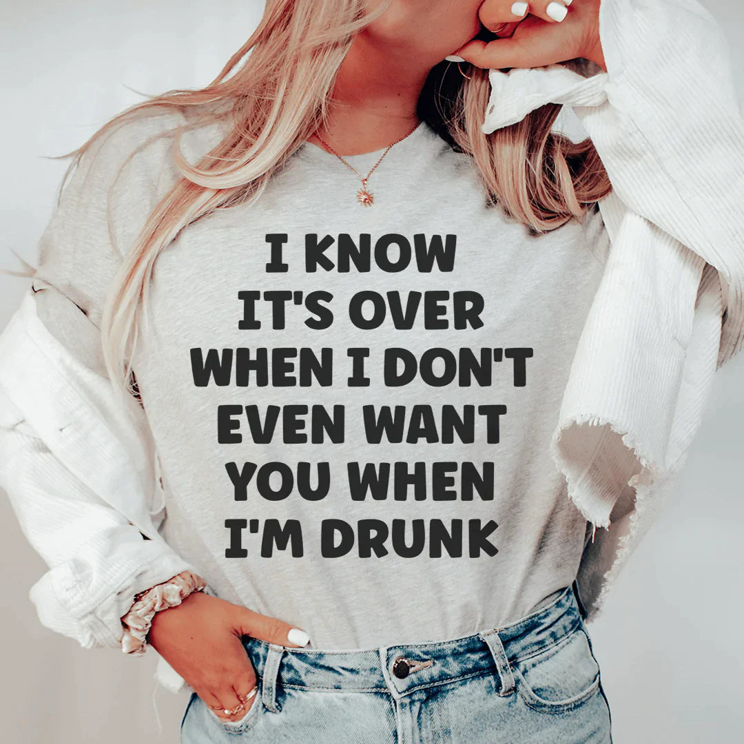 A stylish black t-shirt featuring the phrase 'I Know It's Over When I Don't Even Want You When I'm Drunk' printed in white, showcasing its soft fabric and durable stitching.
