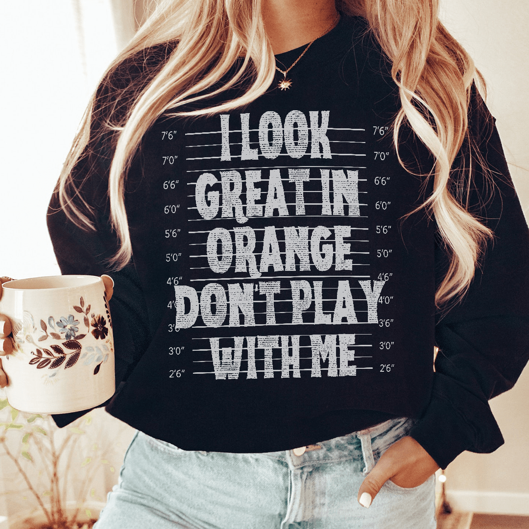 A vibrant orange sweatshirt featuring unique artistic designs, showcasing a cozy fleece lining and adjustable cuffs.