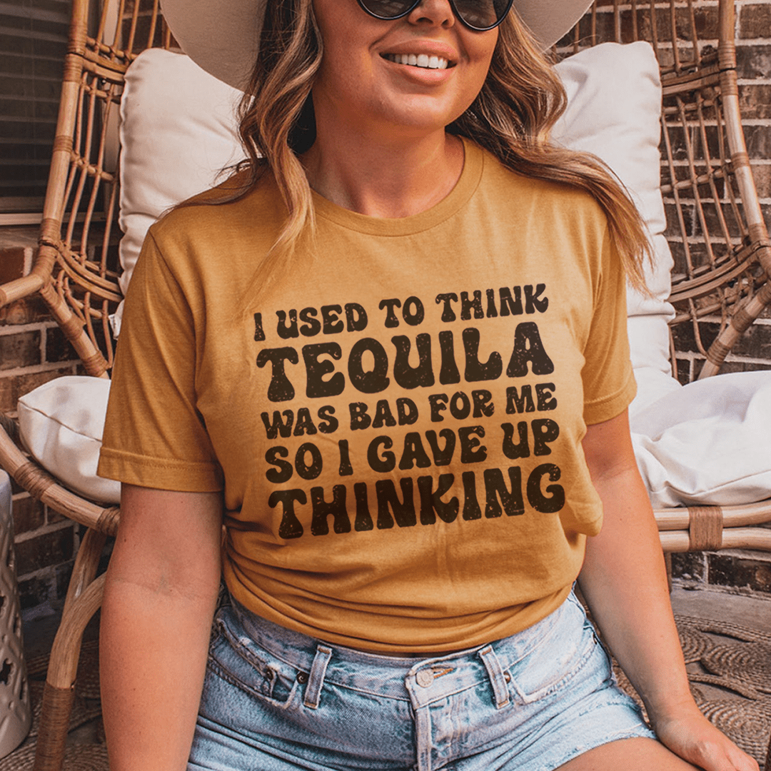 A stylish t-shirt featuring the phrase 'I Used To Think Tequila Was Bad For Me', made from soft cotton with double stitching.
