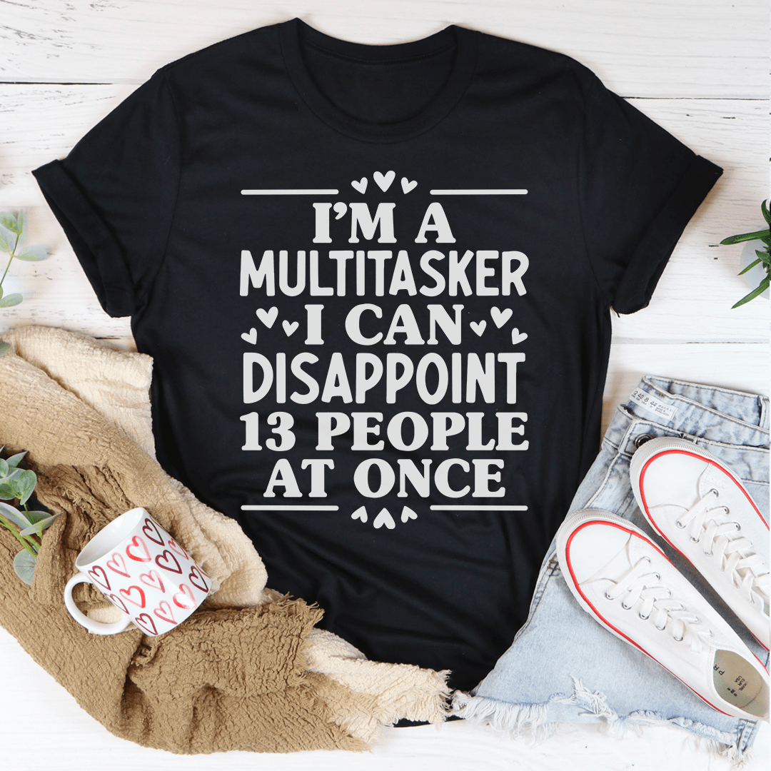 A humorous t-shirt featuring the phrase 'I'm A Multitasker I Can Disappoint 13 People At Once' printed on soft cotton fabric.