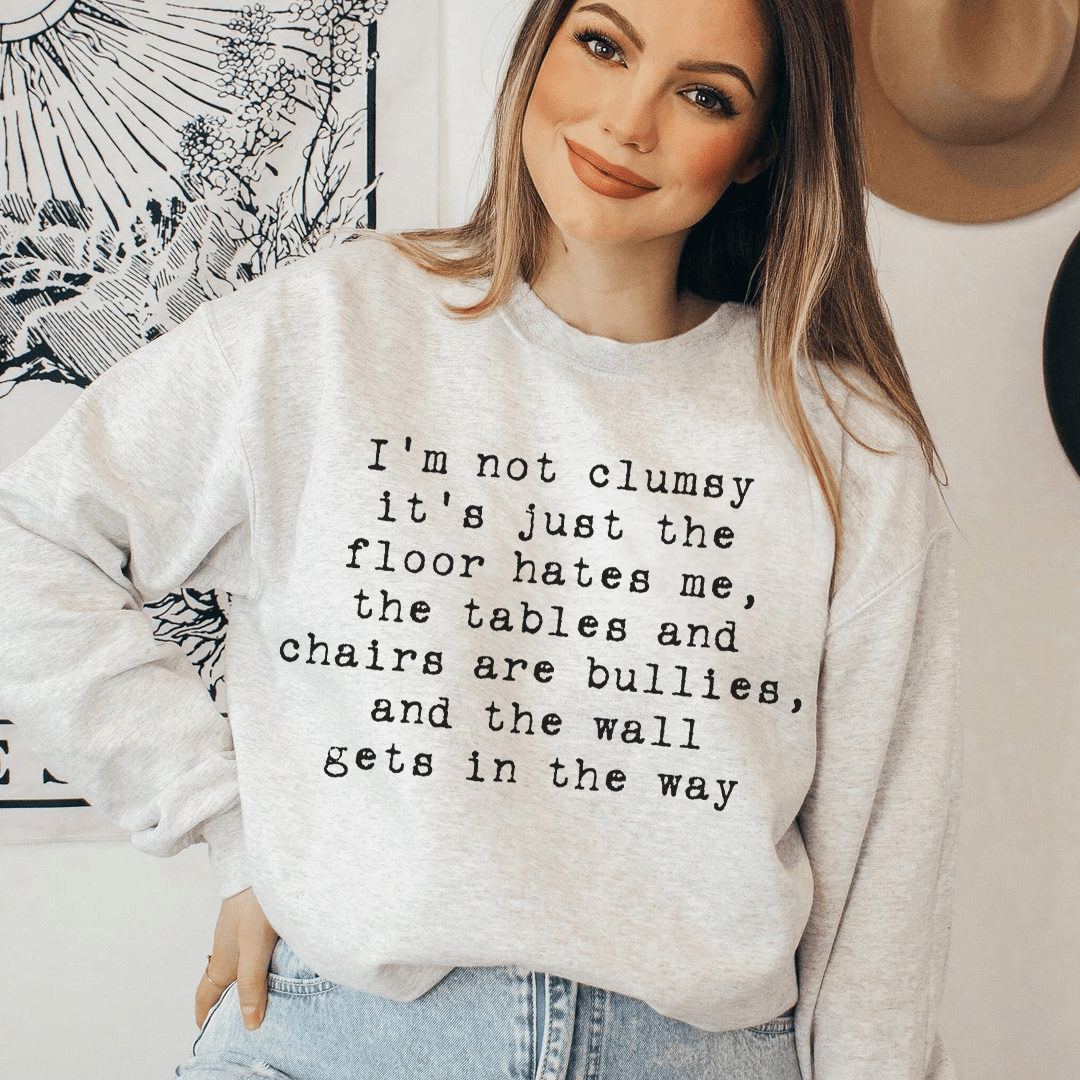 A cozy 'I'm Not Clumsy' hoodie featuring a unique design by top artists, made from a soft cotton/poly fleece blend.
