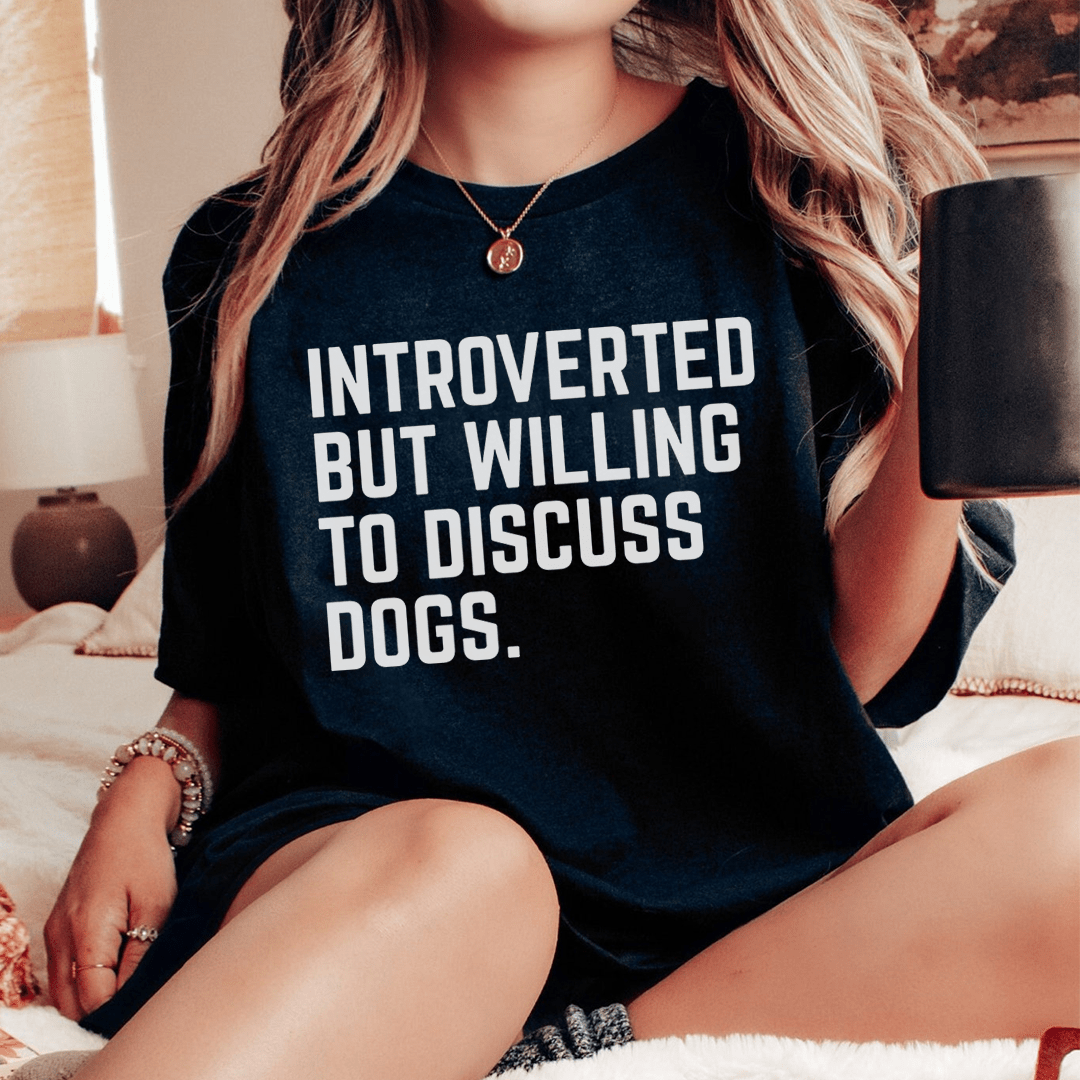 A comfortable t-shirt featuring the phrase 'Introverted But Willing To Discuss Dogs', made from soft cotton with double stitching.