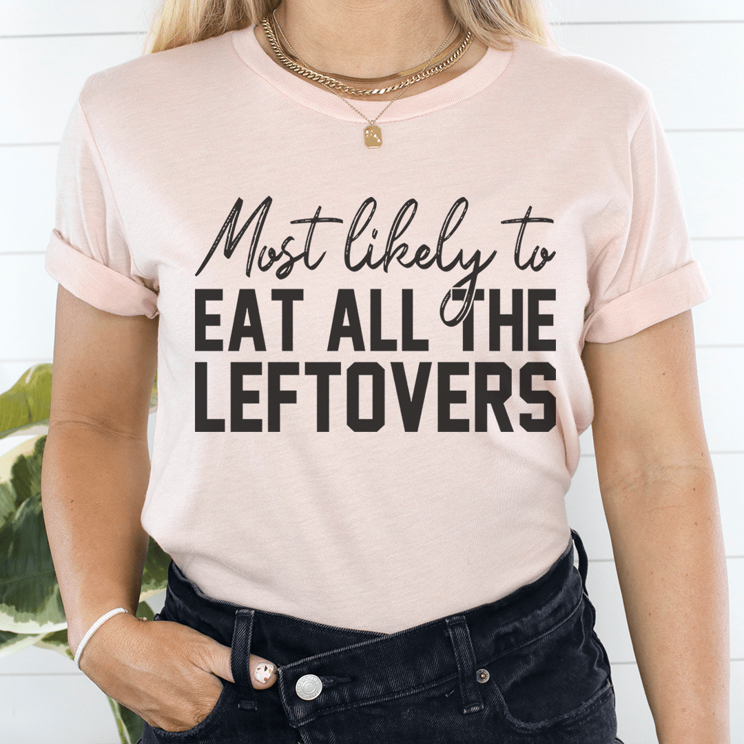 A comfortable Thanksgiving t-shirt featuring the phrase 'Most Likely To Eat All The Leftovers' printed in a fun font.