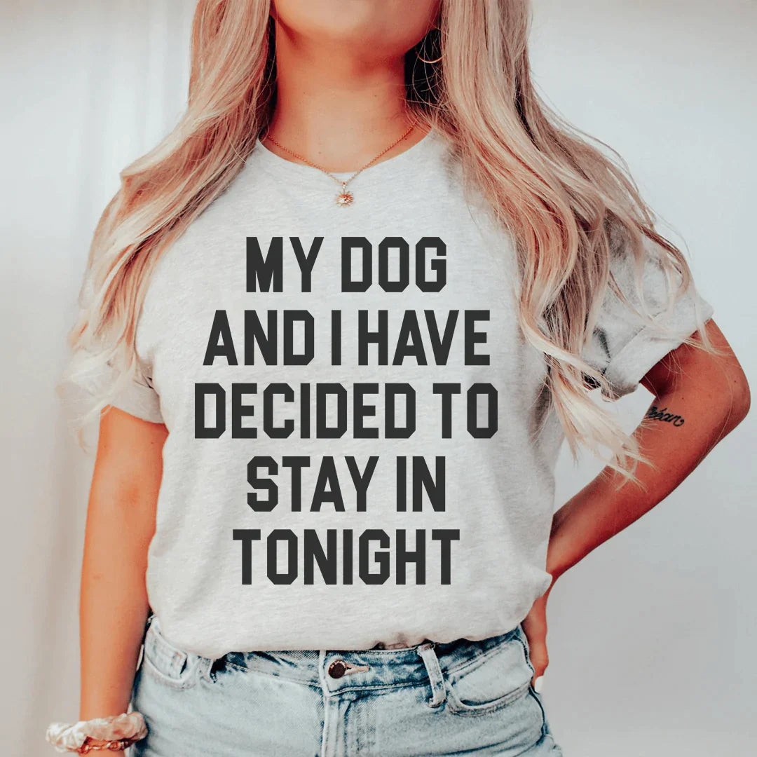 A cozy t-shirt featuring the phrase 'My Dog And I Have Decided To Stay In Tonight', made from soft cotton with double stitching.