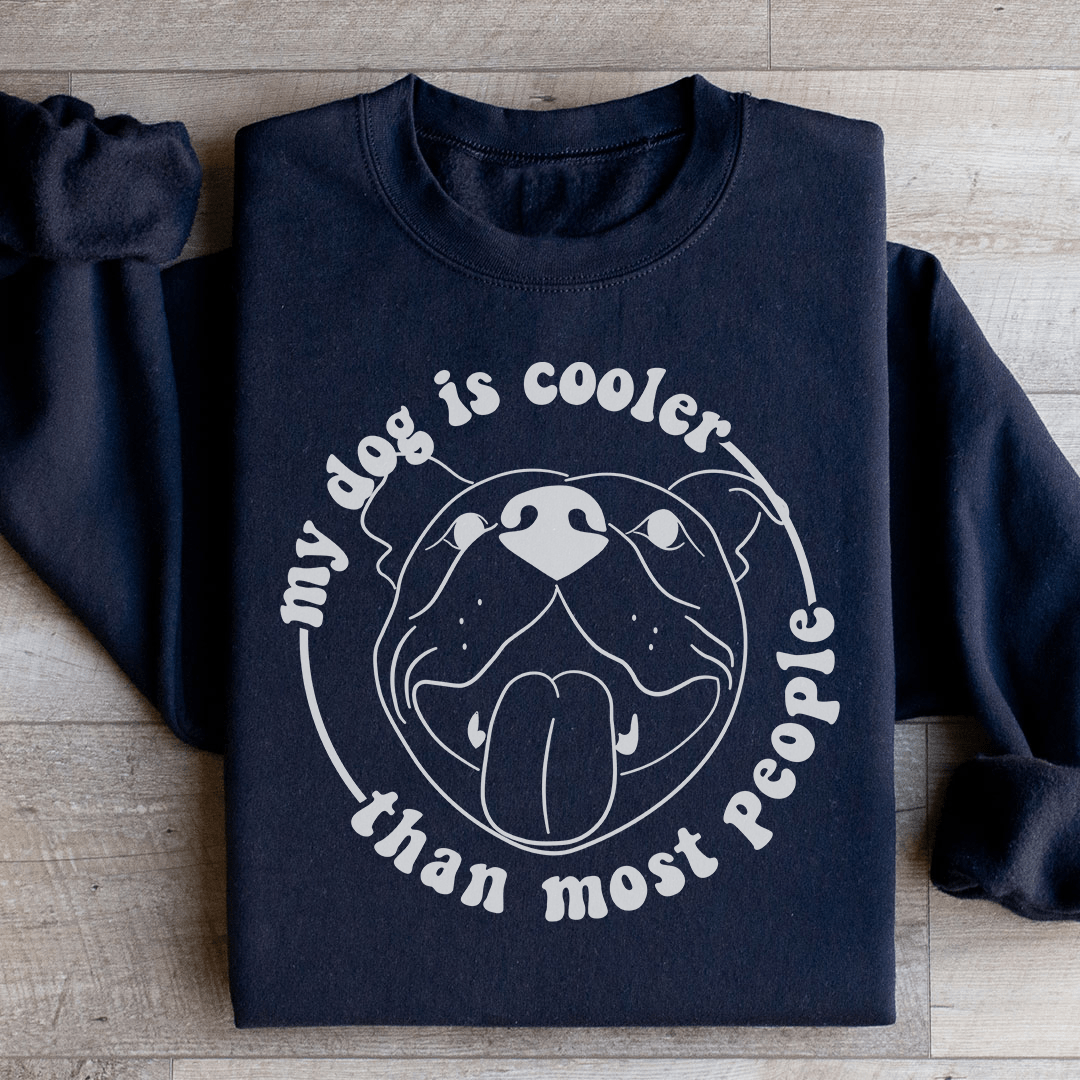 A cozy hoodie featuring the phrase 'My Dog Is Cooler Than Most People', designed by top artists, showcasing a unique and stylish look.