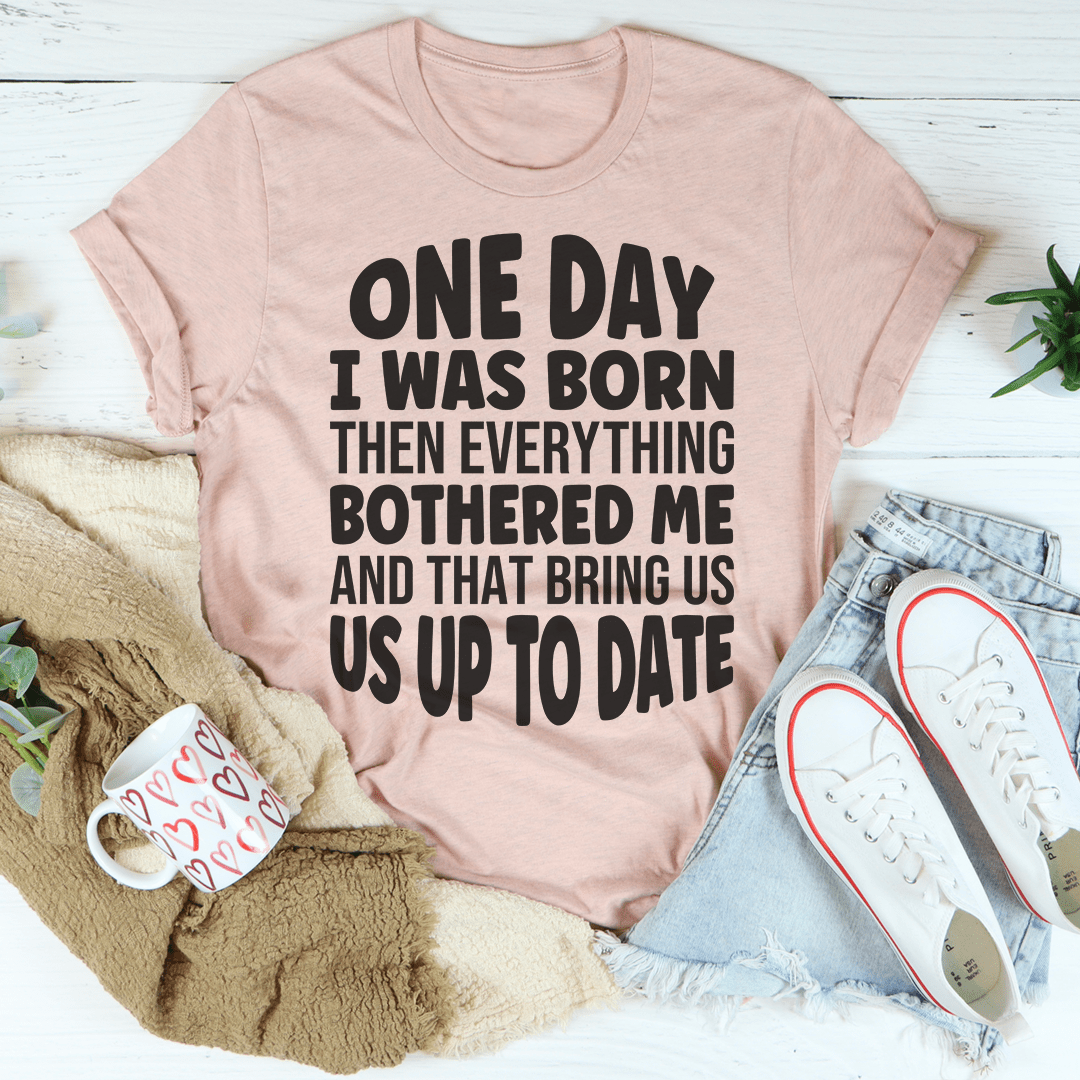 A comfortable and stylish t-shirt featuring the phrase 'One Day I Was Born Then Everything Bothered Me', made from soft ring-spun cotton.