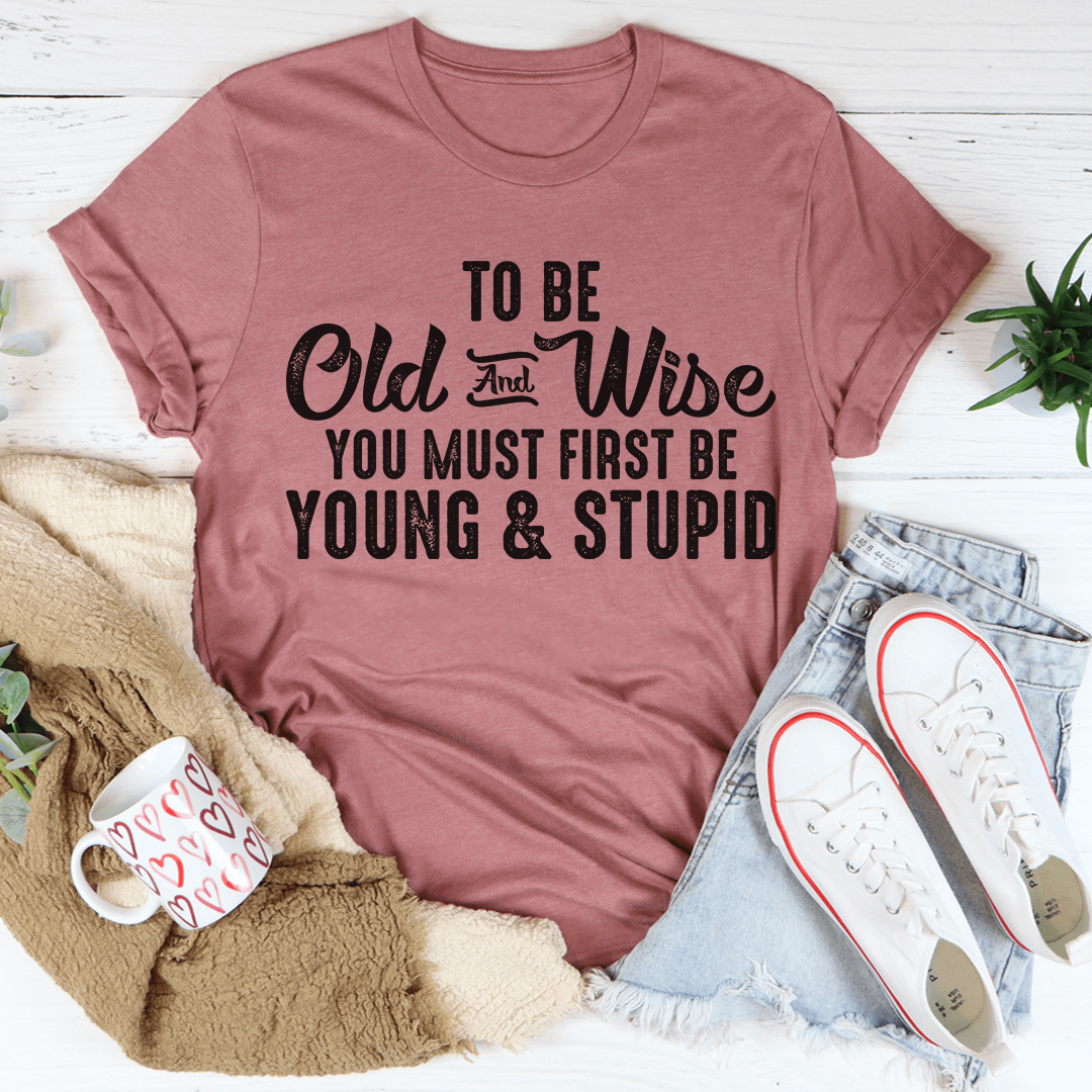 To Be Old & Wise Tee in various colors, showcasing its soft cotton fabric and double stitching details.
