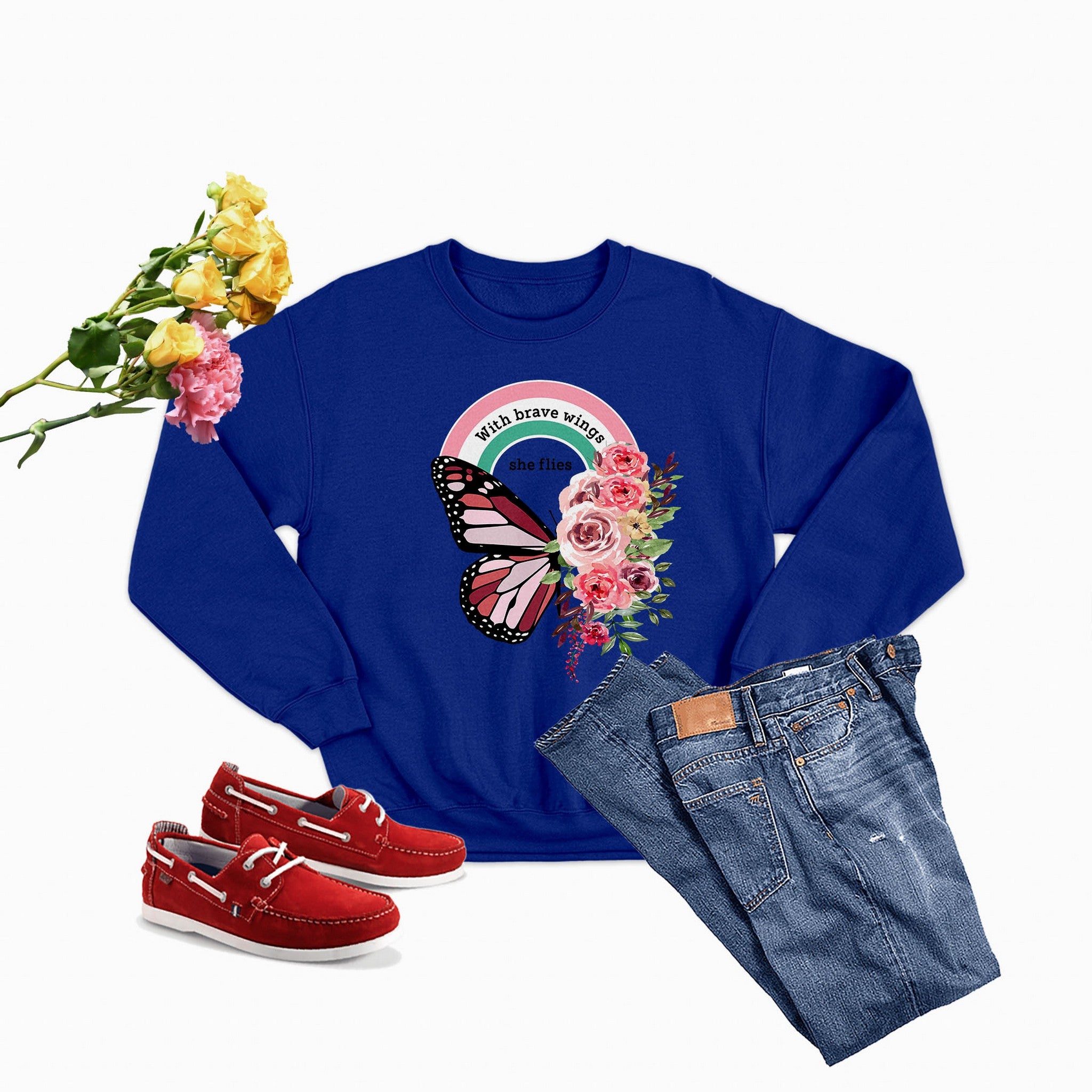 A cozy sweatshirt featuring the phrase 'With Brave Wings She Flies', designed for comfort and style, made from a cotton/poly fleece blend.