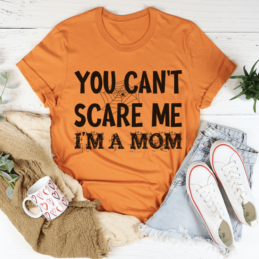 A stylish black t-shirt with the phrase 'You Can't Scare Me I'm A Mom' printed in bold letters, showcasing a comfortable and durable design.