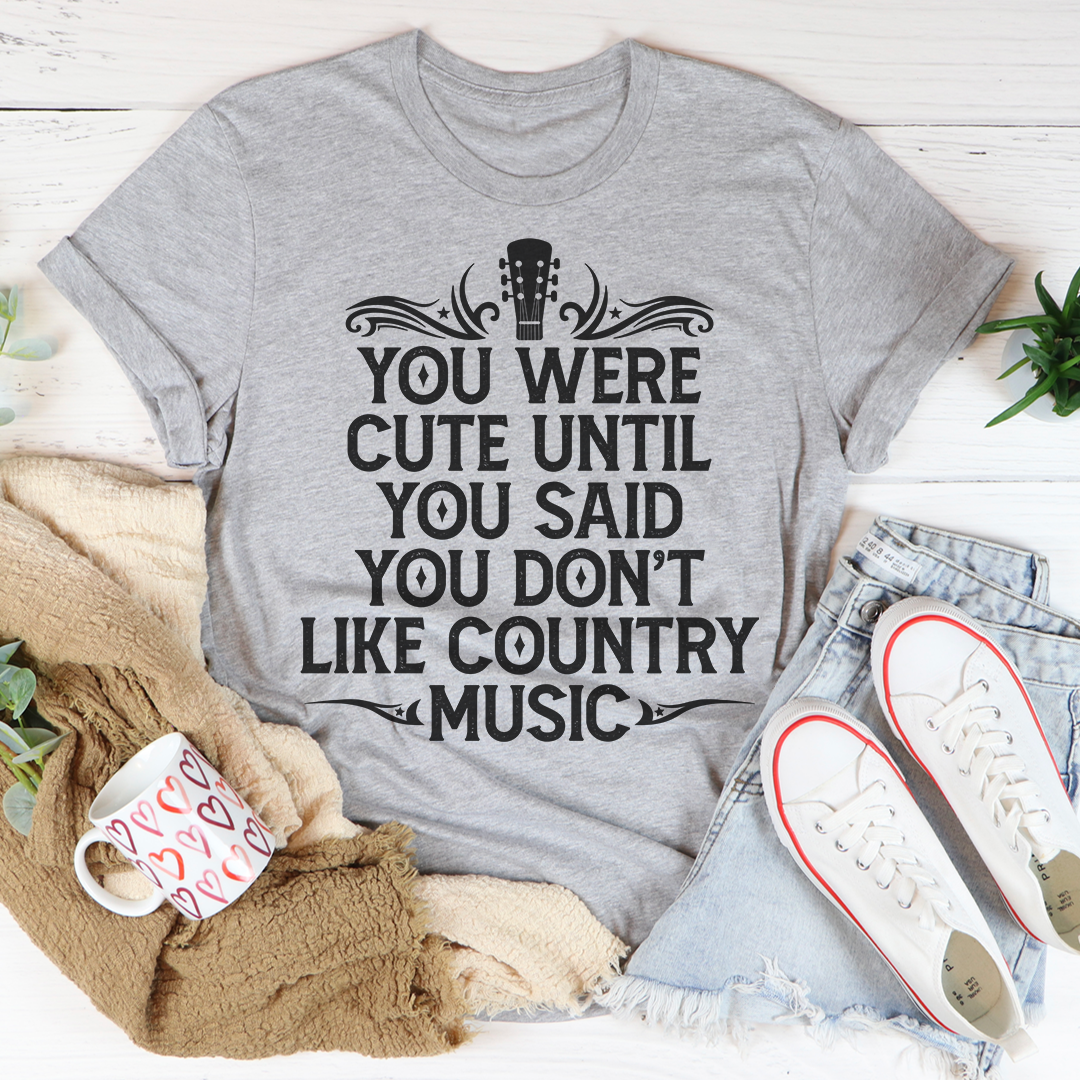 A stylish t-shirt featuring the phrase 'You Were Cute Until You Said You Don't Like Country Music' printed on soft cotton fabric.