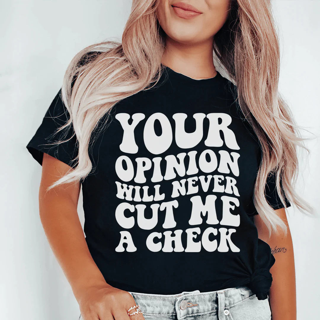 A stylish black t-shirt with the phrase 'Your Opinion Will Never Cut Me A Check' printed in bold letters, showcasing its soft fabric and durable stitching.