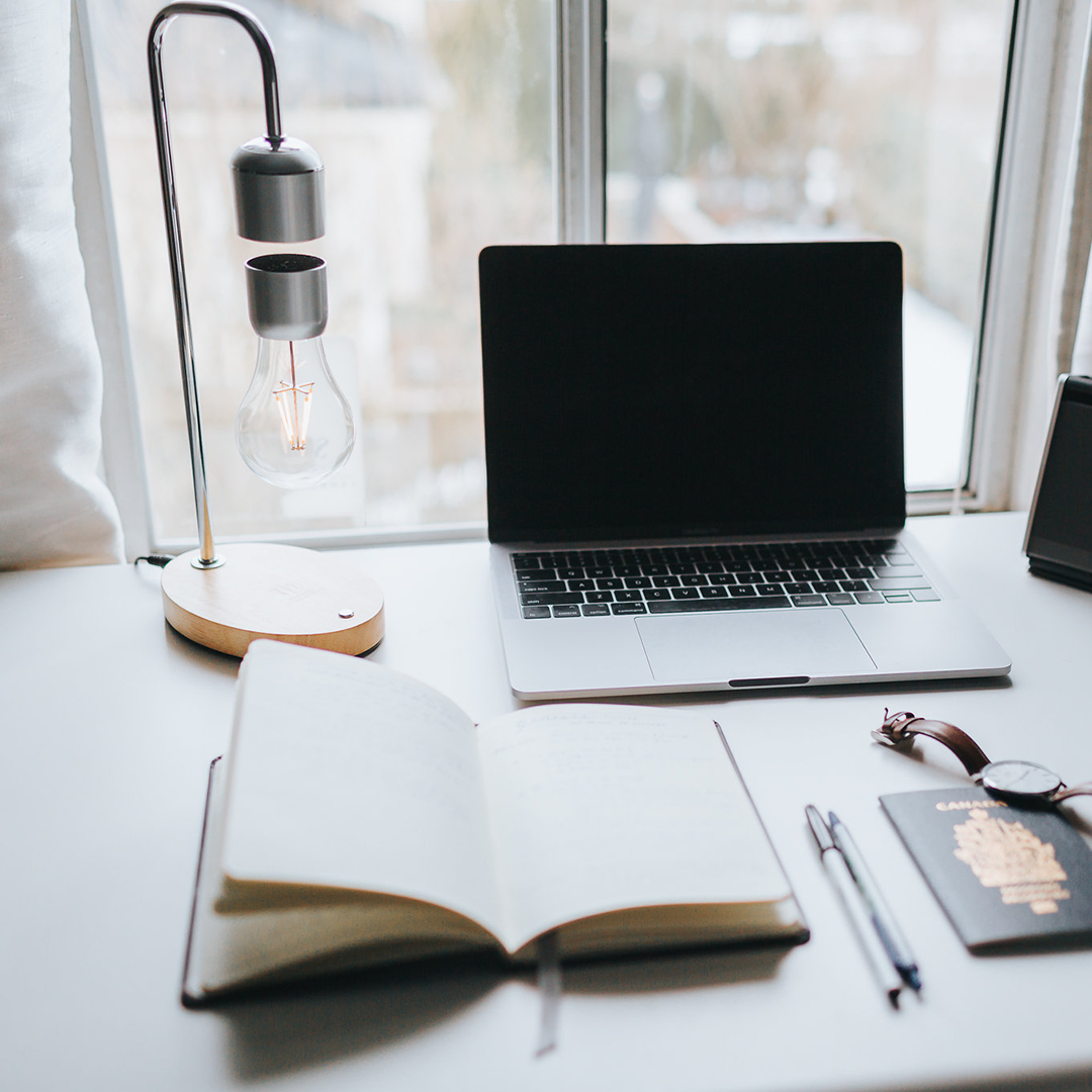 A modern levitating wireless light bulb lamp with a wooden oak finish base and a floating light bulb, showcasing innovative design and technology.