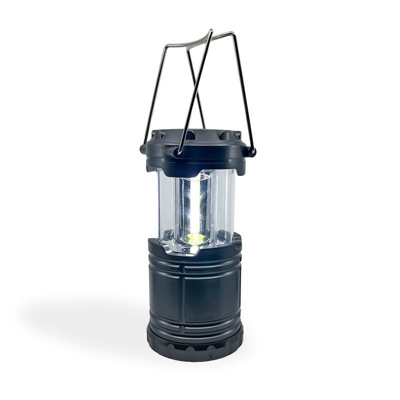 Slide-N-Glo COB LED Pop-Up Lantern displayed in a retail setting, showcasing its compact design and bright illumination.