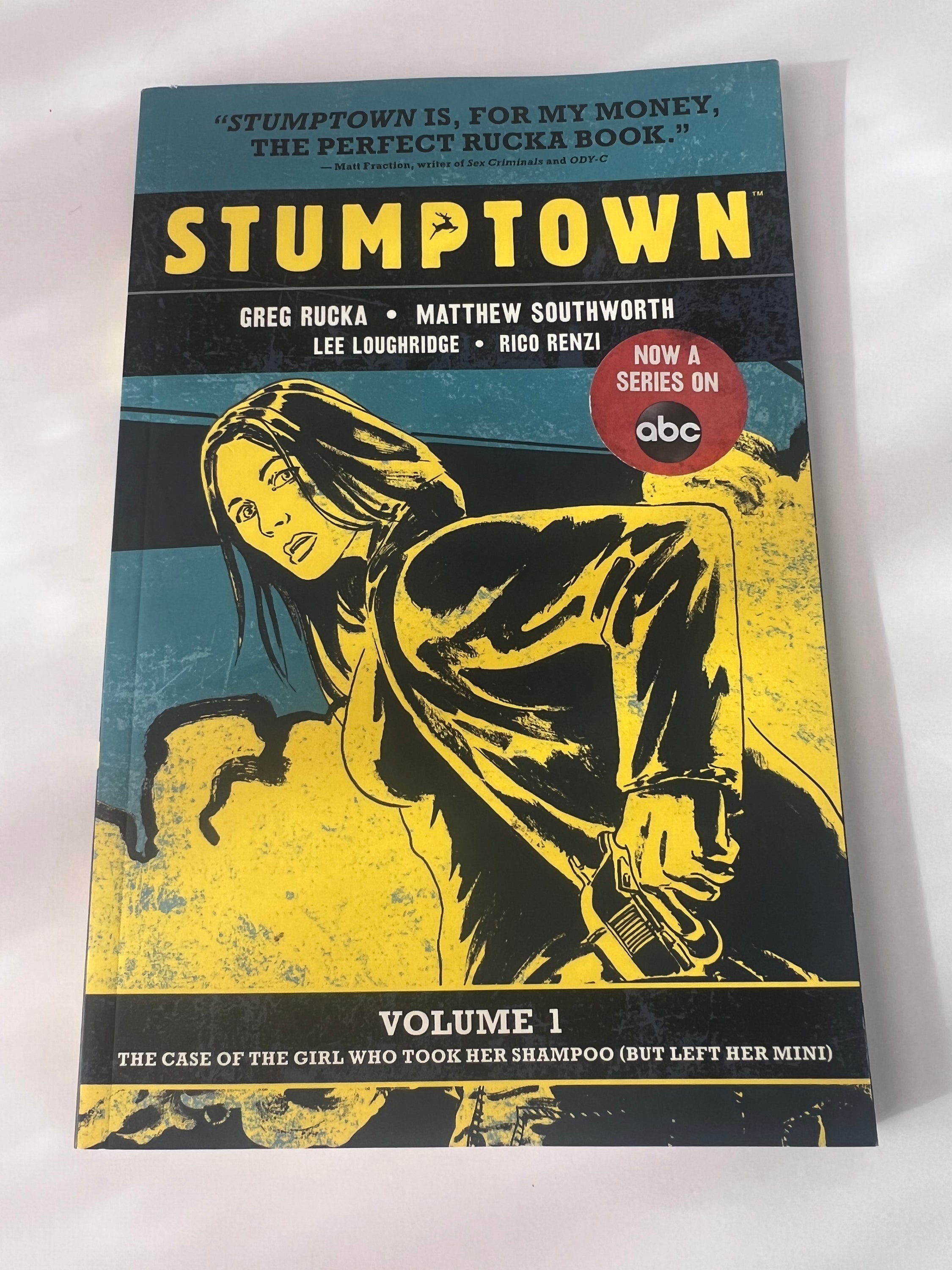 Stumptown Volume 1 paperback by Greg Rucka featuring Dex Parios on the cover, illustrated by Matthew Southworth.