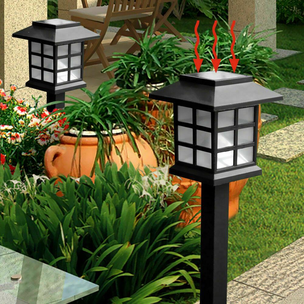 A set of 12 LED solar-powered garden lights illuminating a pathway, showcasing their sleek design and bright white light.