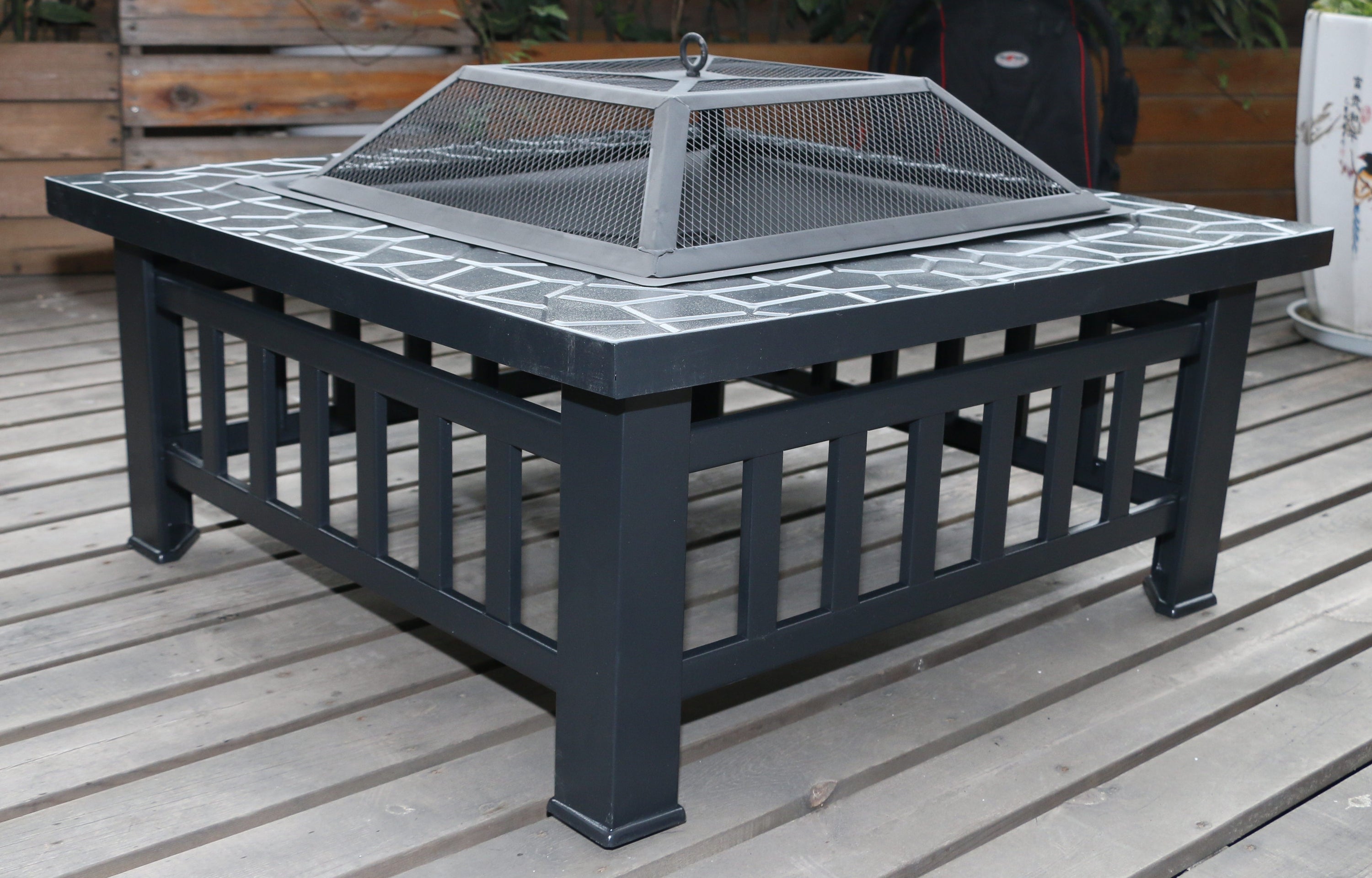 18-inch square metal fire pit outdoor heater with faux-stone finish, mesh screen lid, and poker, perfect for grilling and warmth.