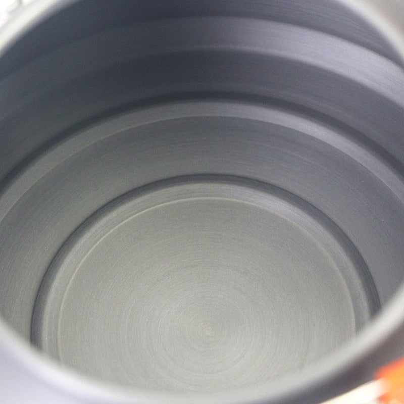 1.1L Camping Water Kettle made of aluminium alloy, perfect for outdoor coffee and cooking, shown in a natural setting.