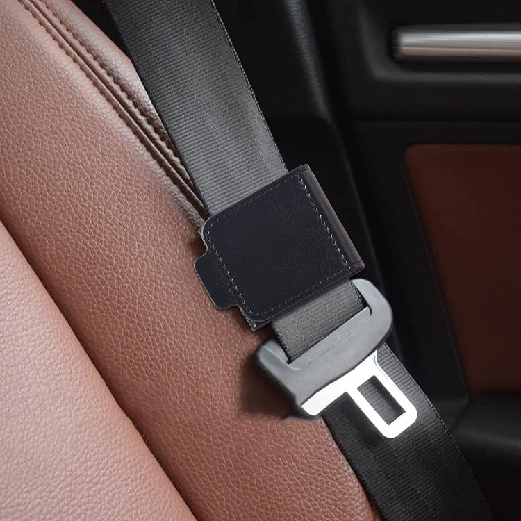 A pair of black car seat belt anti-strangle adjusters designed for children and adults, showcasing their compact size and high-quality leather material.