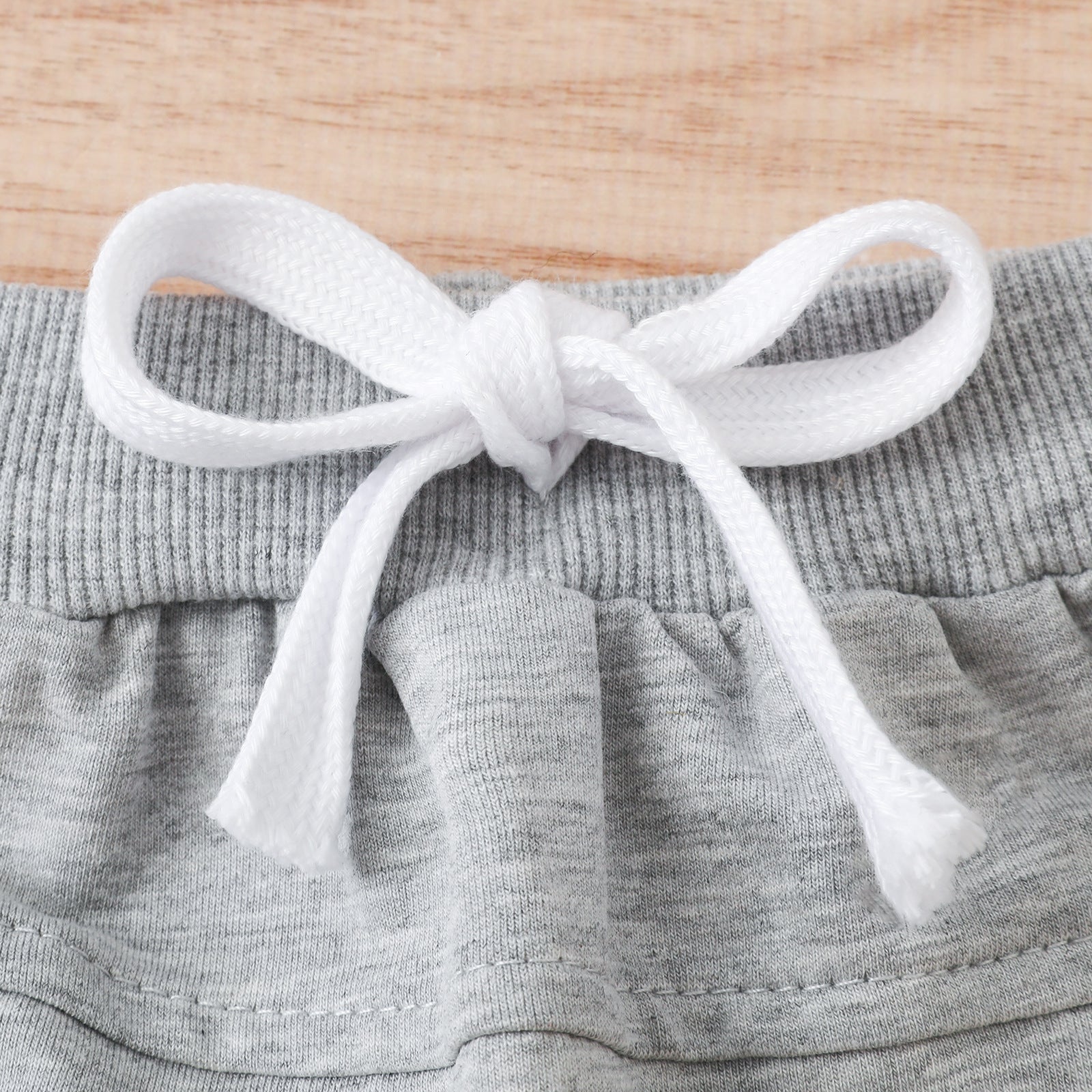 A stylish 2-piece set for babies featuring a letter-patterned T-shirt and solid color shorts, perfect for summer wear.