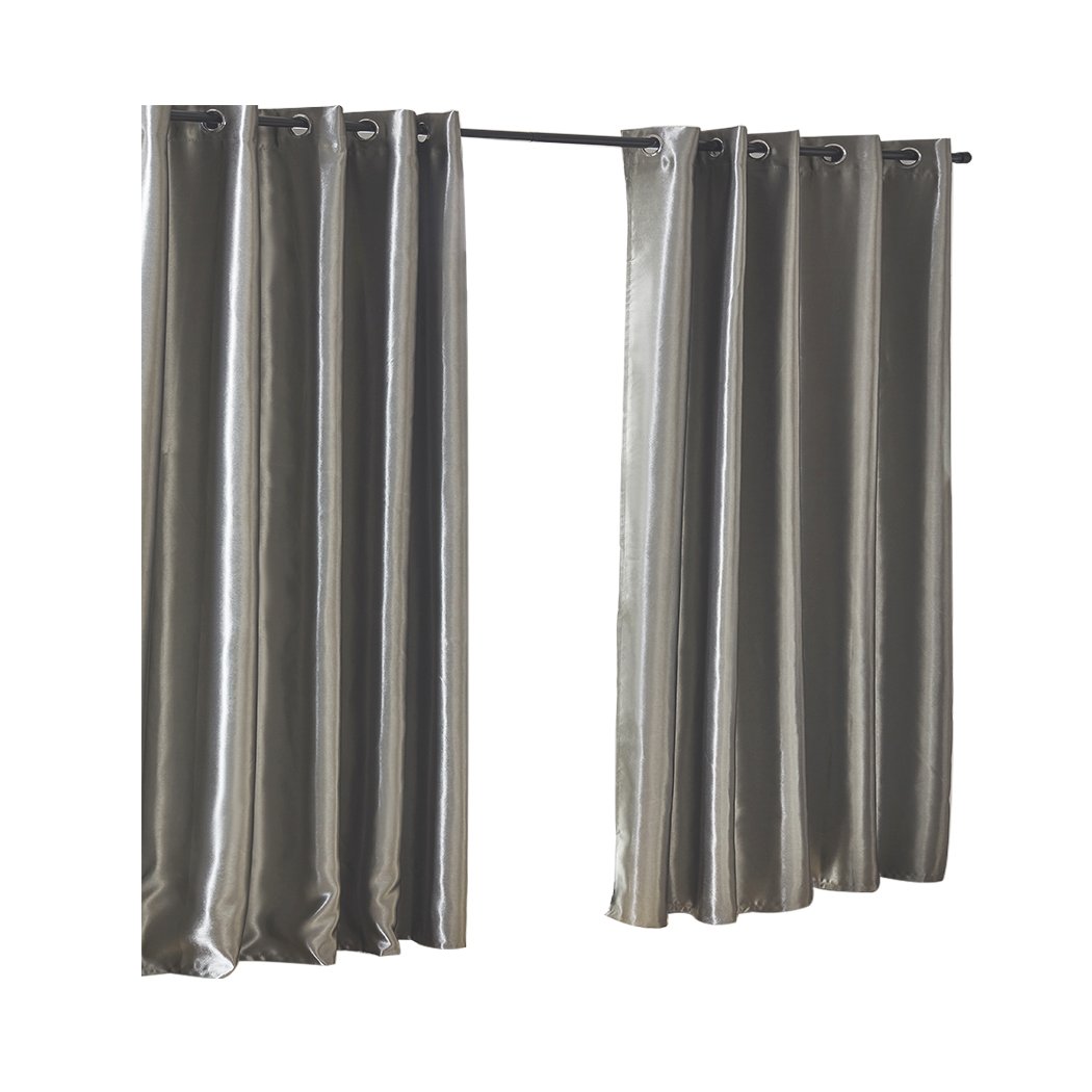 Elegant grey 2X blockout curtains hanging in a bedroom, showcasing their thick fabric and stylish design.