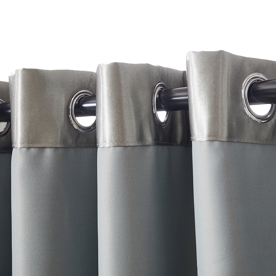 Elegant grey 2X blockout curtains hanging in a bedroom, showcasing their thick fabric and stylish design.