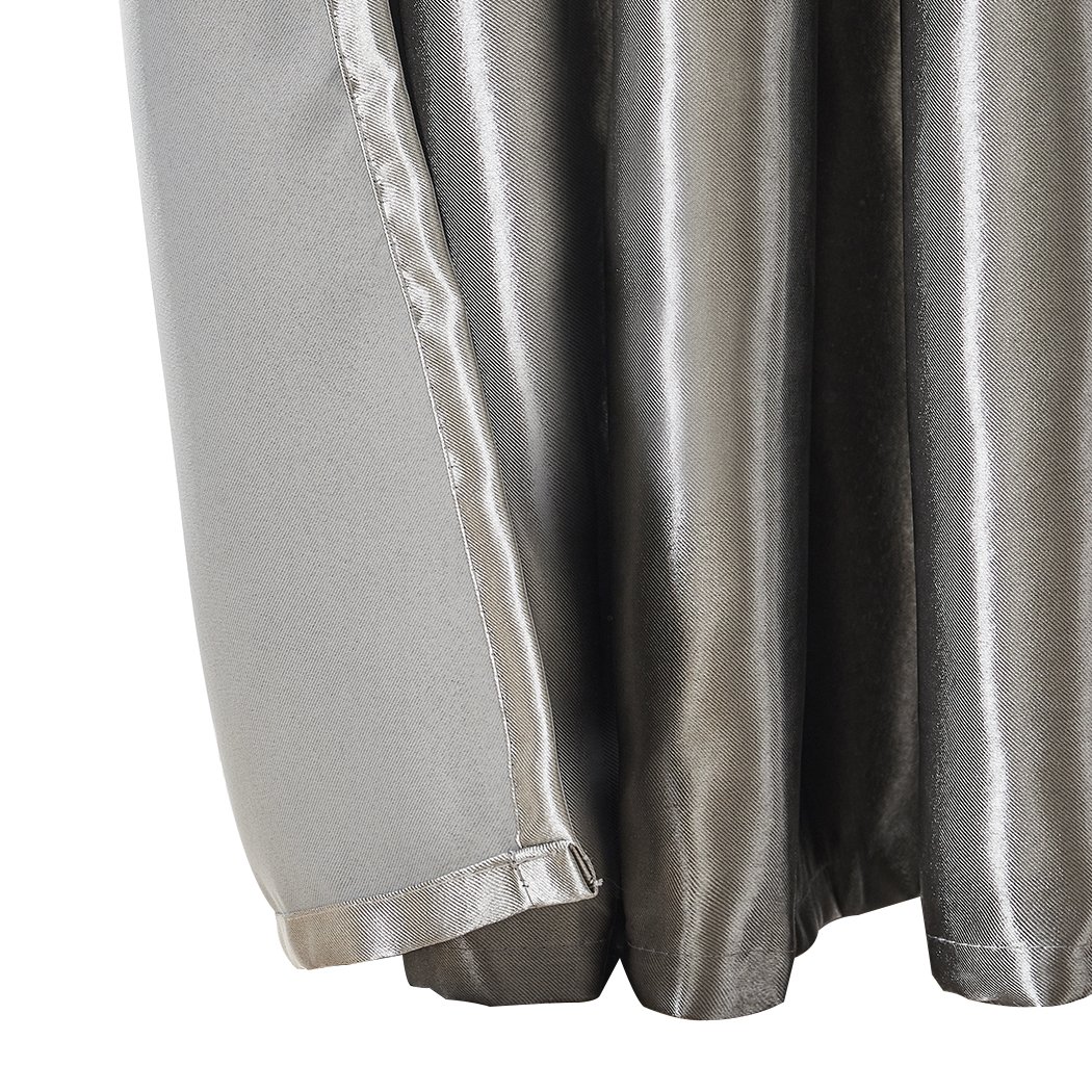 Elegant grey 2X blockout curtains hanging in a bedroom, showcasing their thick fabric and stylish design.