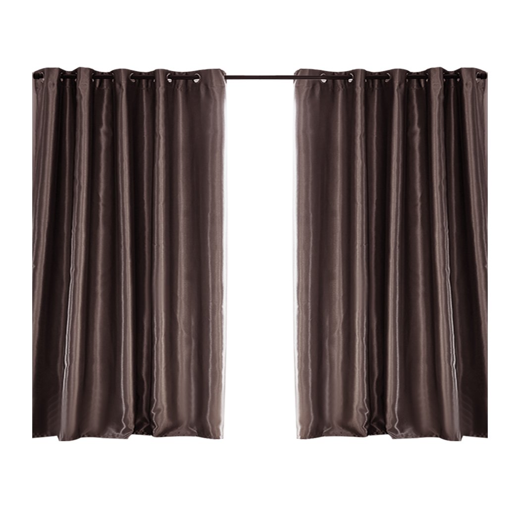 Elegant taupe 2X blockout curtains with eyelet design, providing light and noise blocking for a serene bedroom environment.