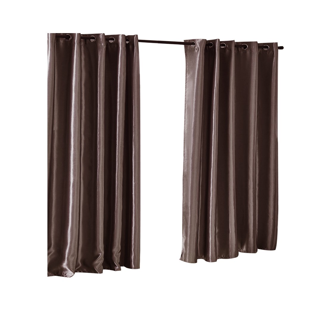 Elegant taupe 2X blockout curtains with eyelet design, providing light and noise blocking for a serene bedroom environment.